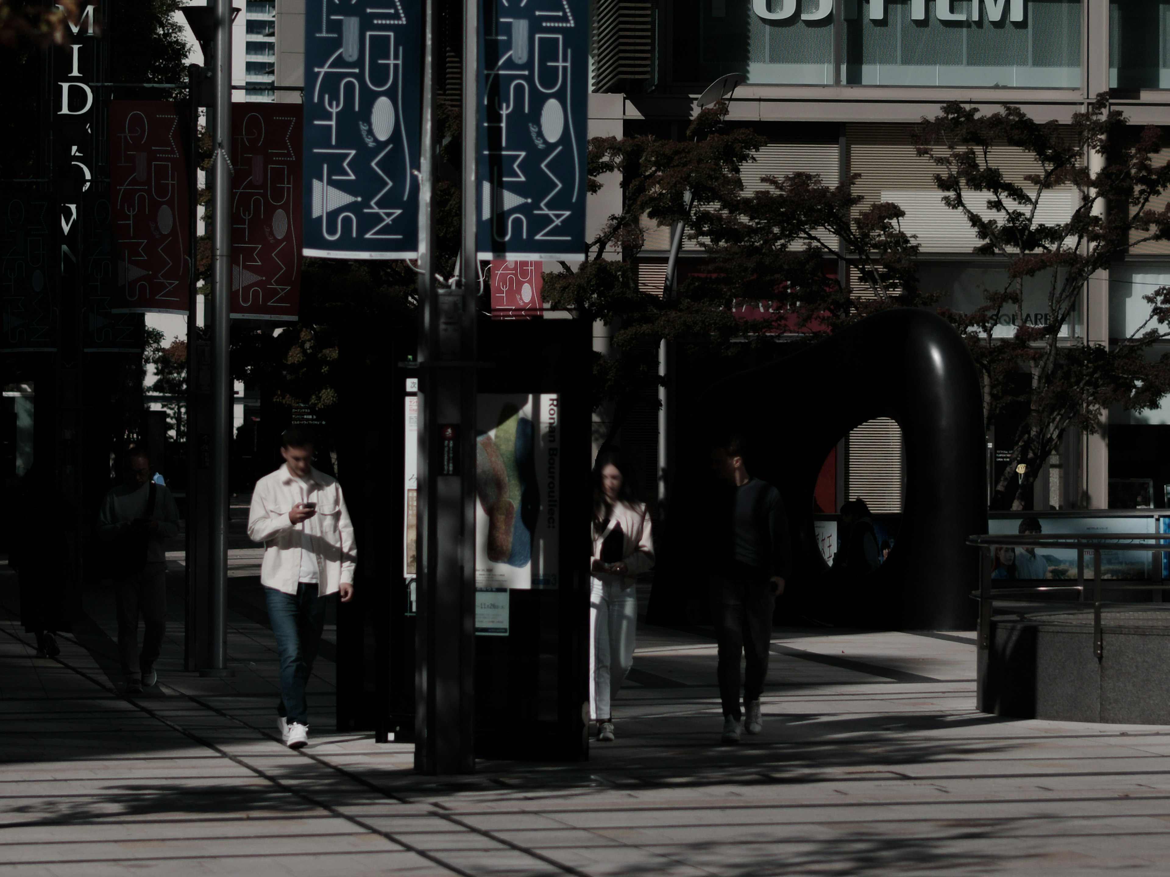 街の風景に立つ人々と電話ボックスのあるシーン