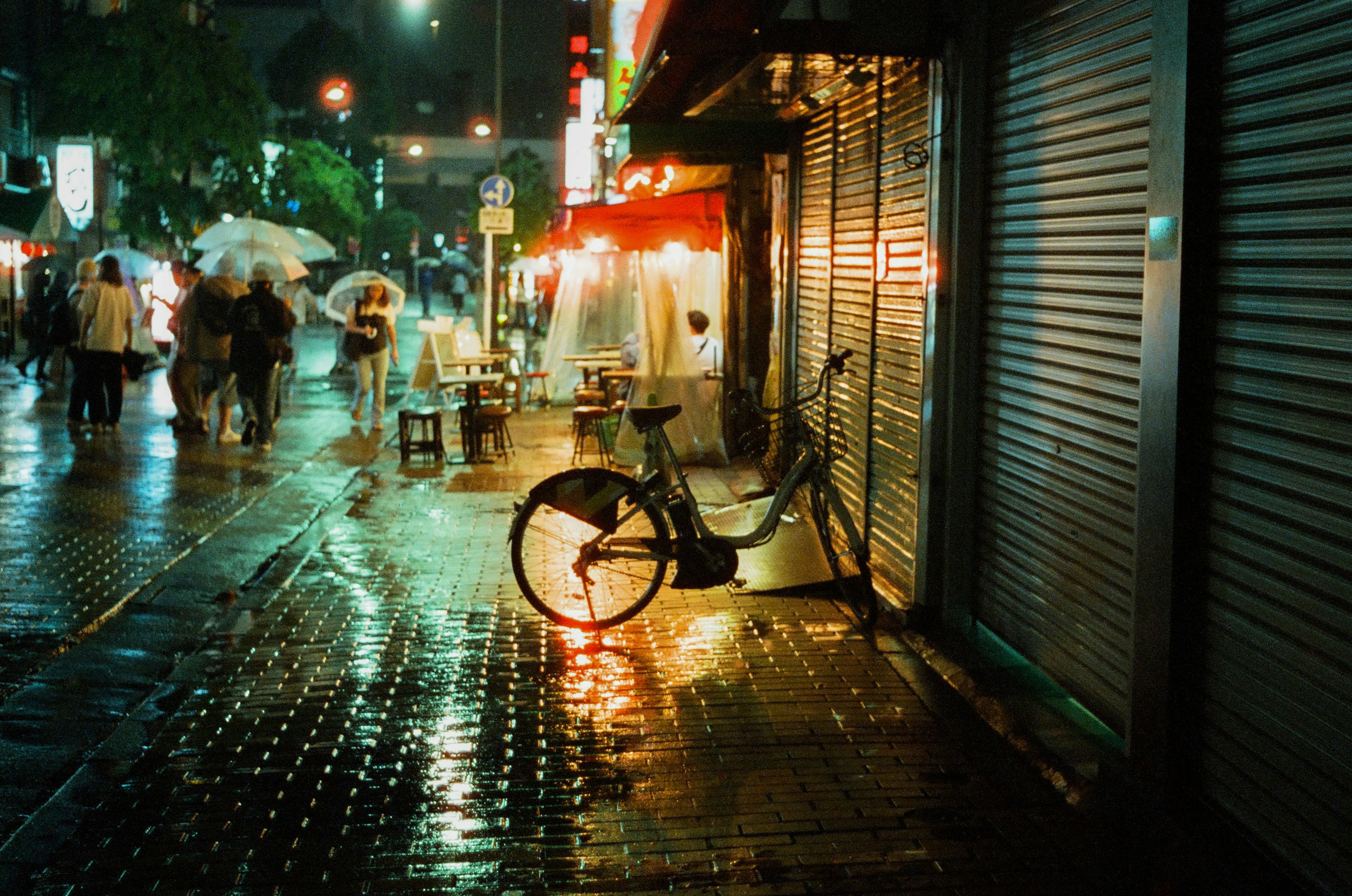 雨中街角停放的自行車和發光的人行道