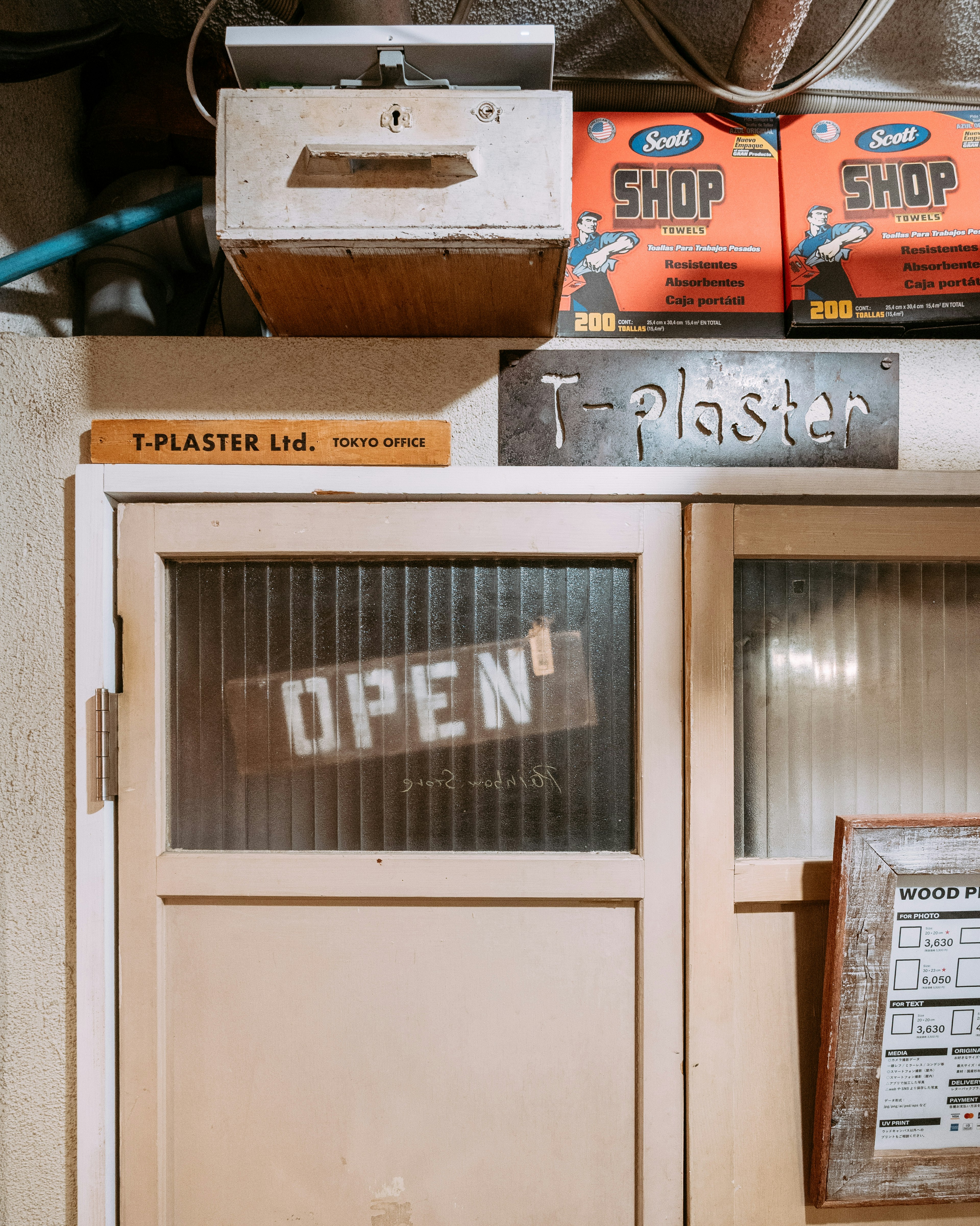 Image of an old door with an open sign and boxes on top