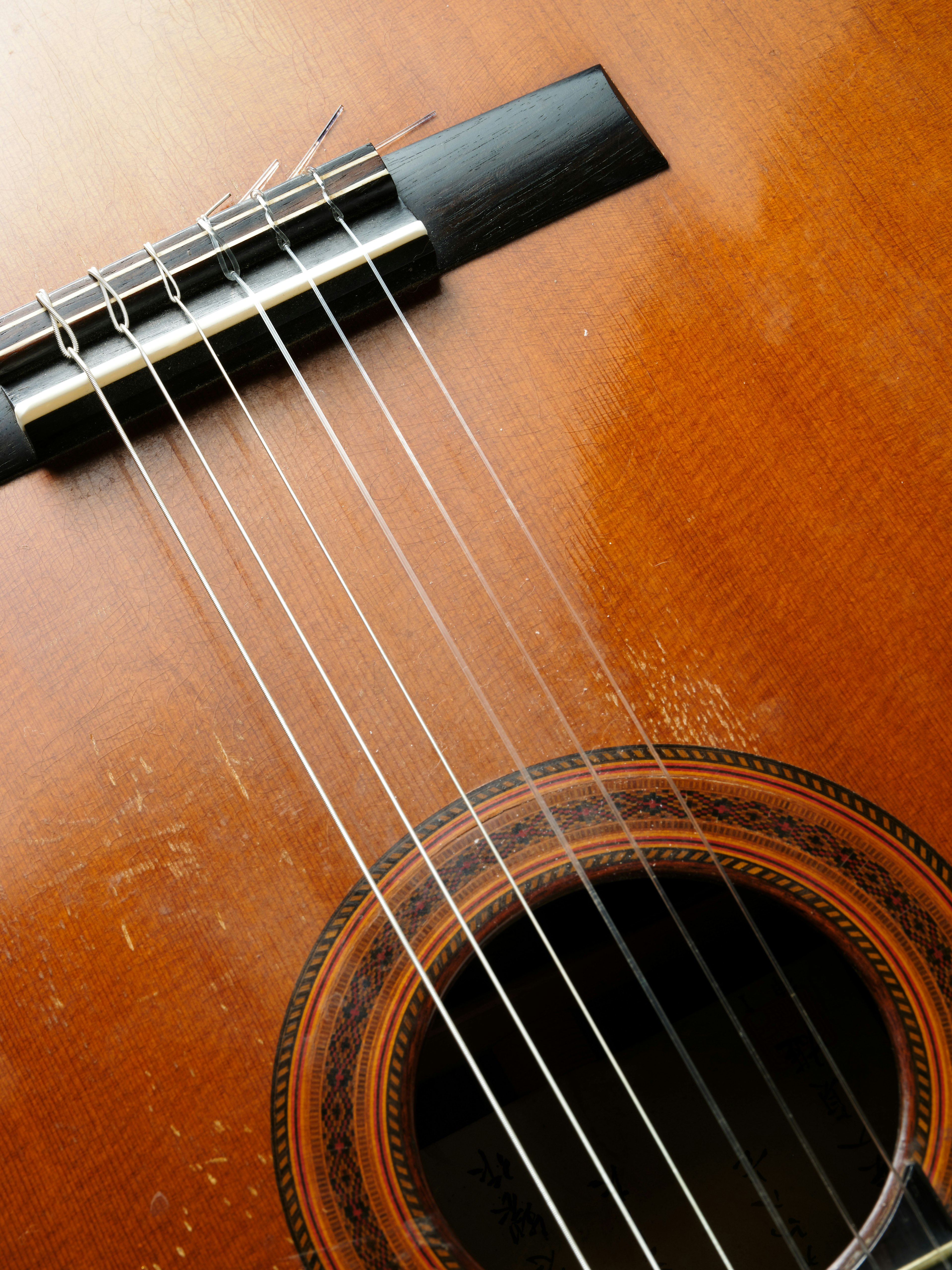 Primo piano delle corde di chitarra e del foro di risonanza