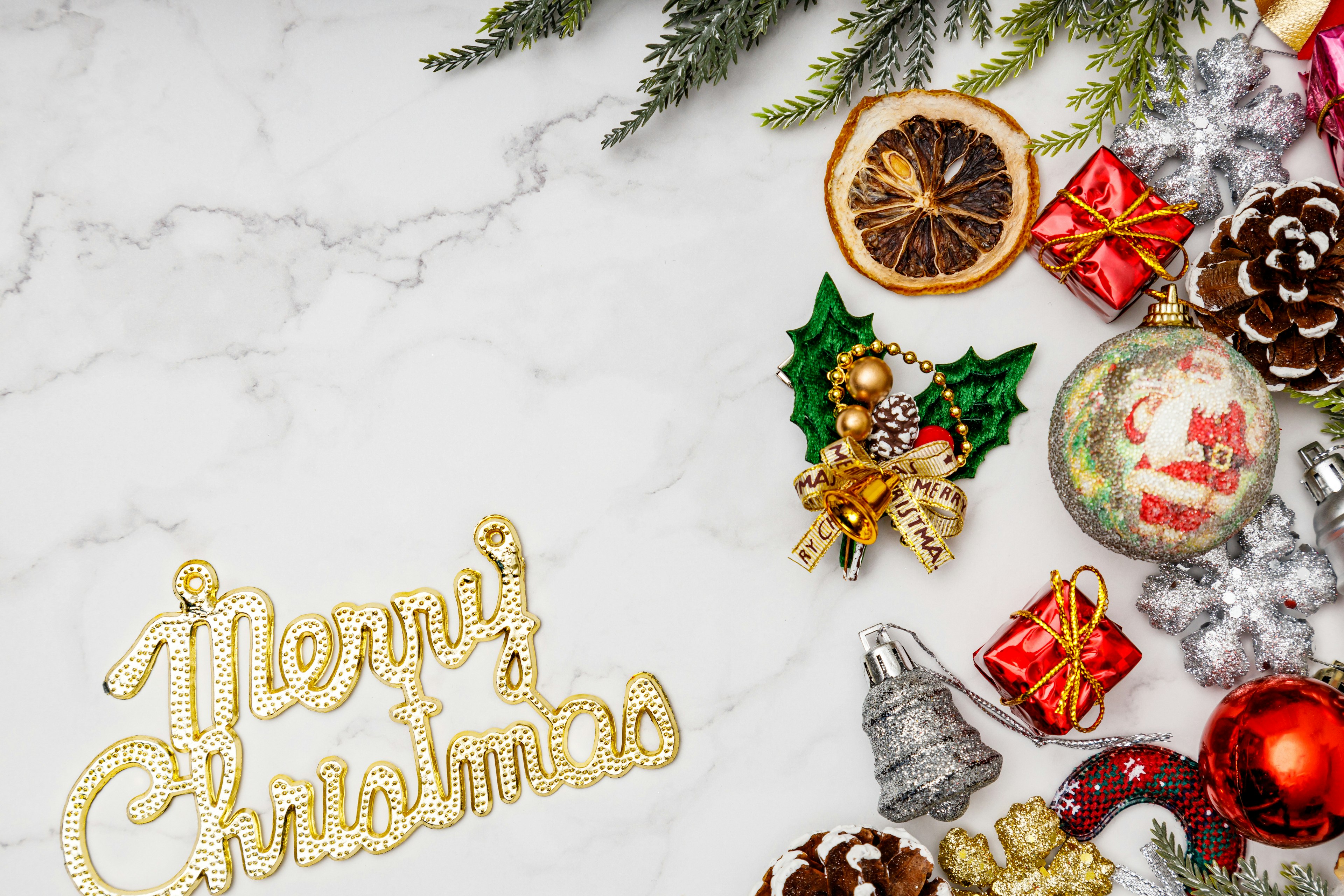 An arrangement of Christmas decorations and gifts on a marble surface