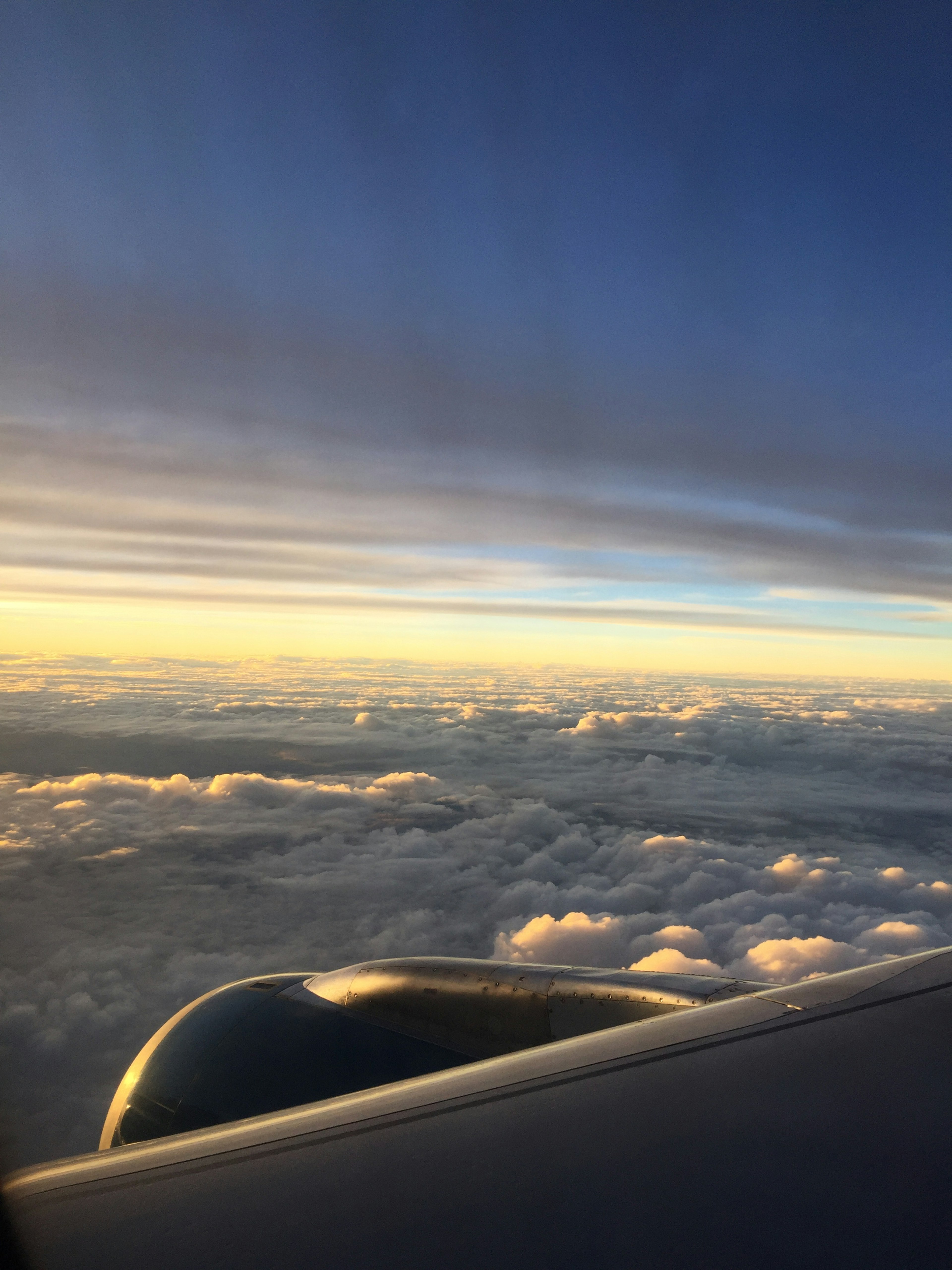 Blick aus einem Flugzeugfenster auf Wolken und Triebwerk