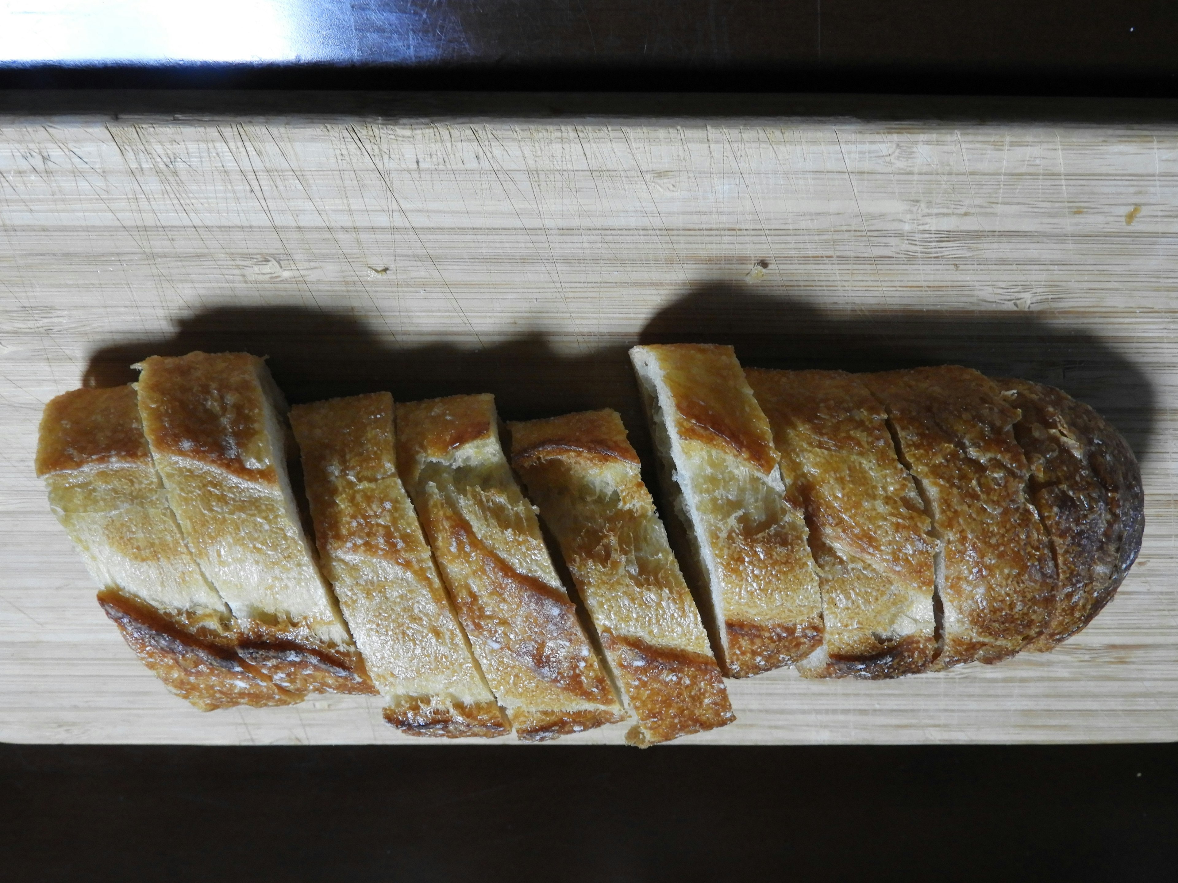 Roti yang diiris di atas papan kayu