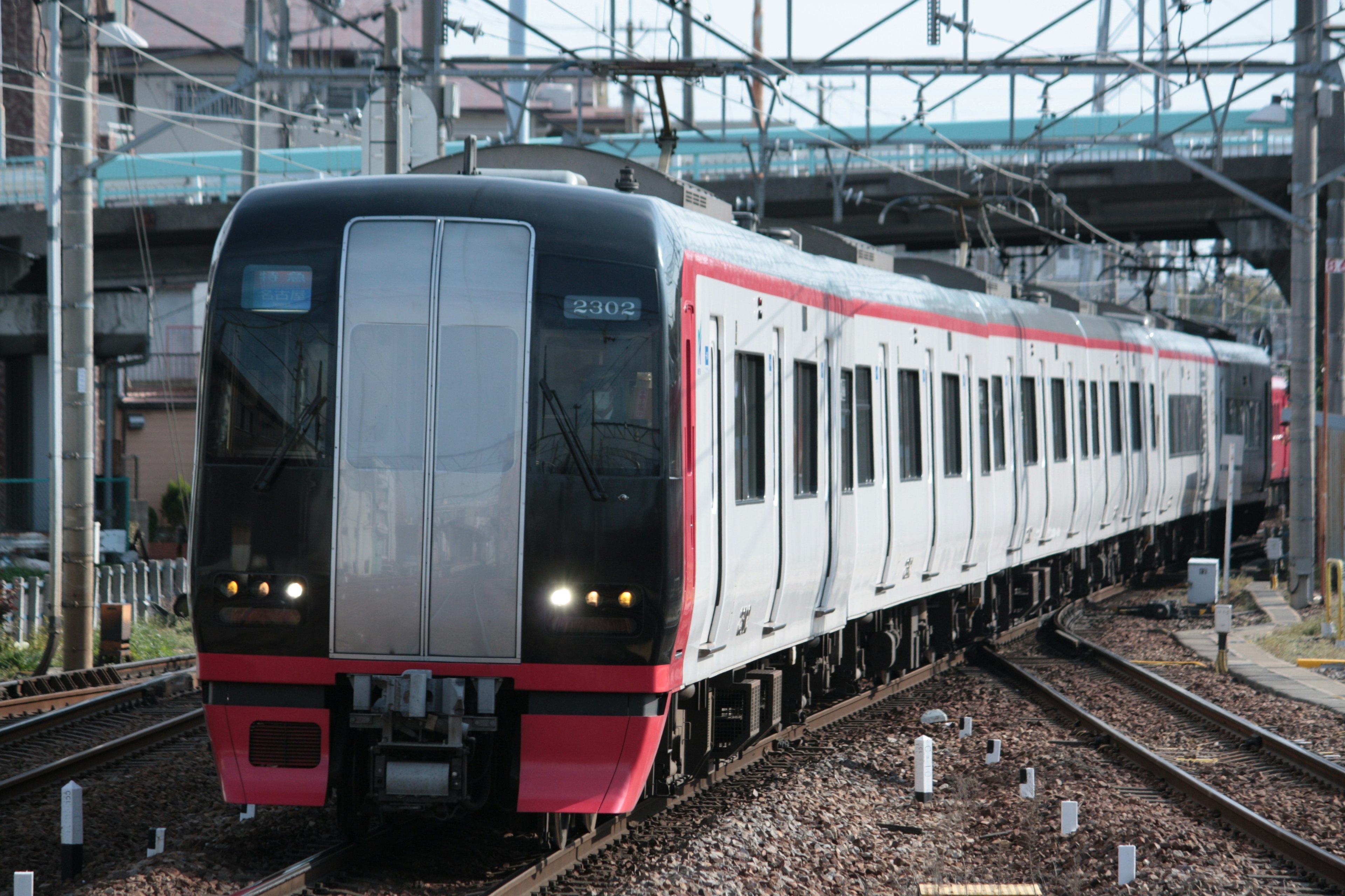 Un treno moderno con una striscia rossa che corre sui binari