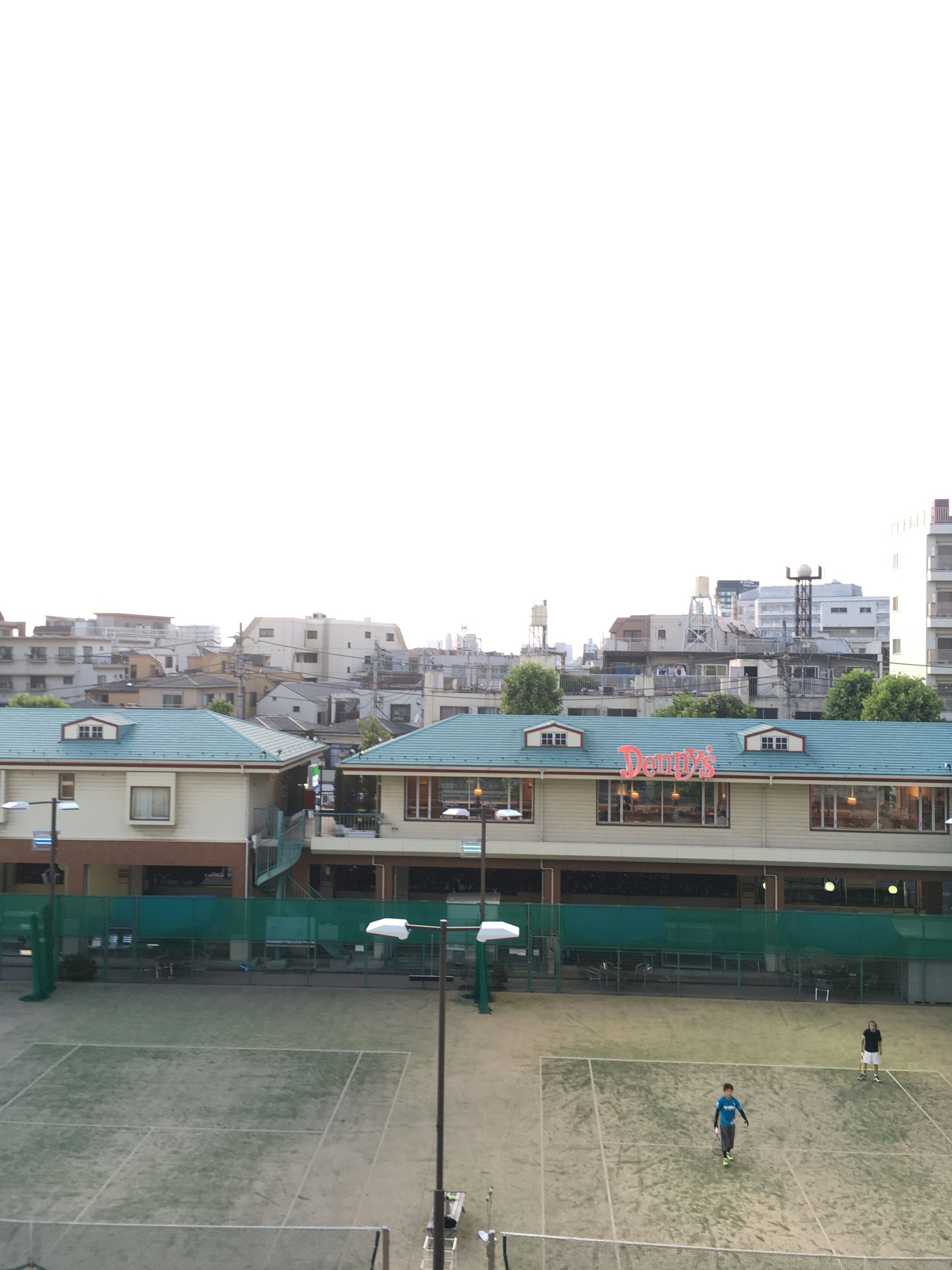 屋外テニスコートと周囲の建物を見渡す景色