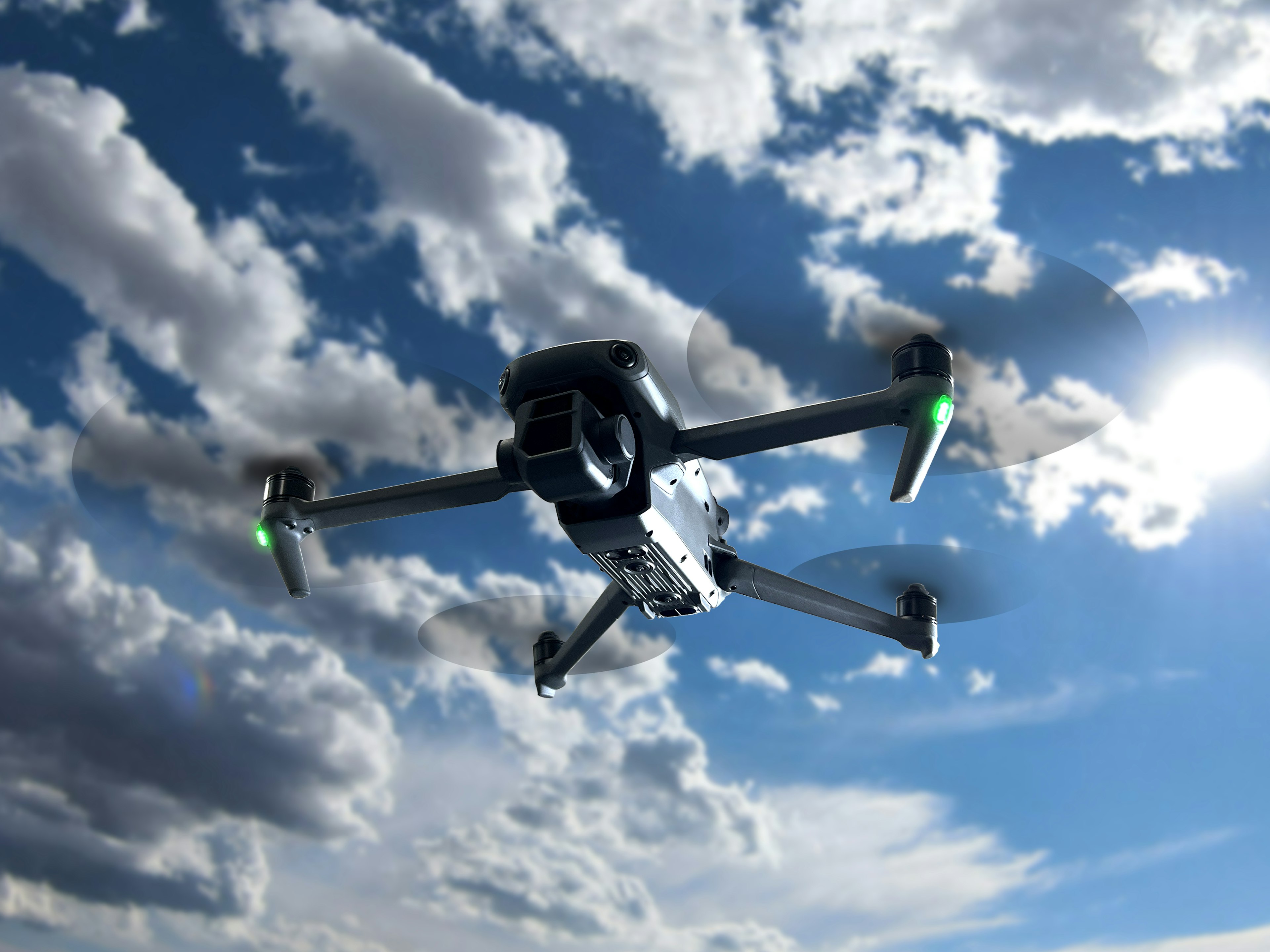 Drone volando contra un fondo de cielo azul y nubes blancas