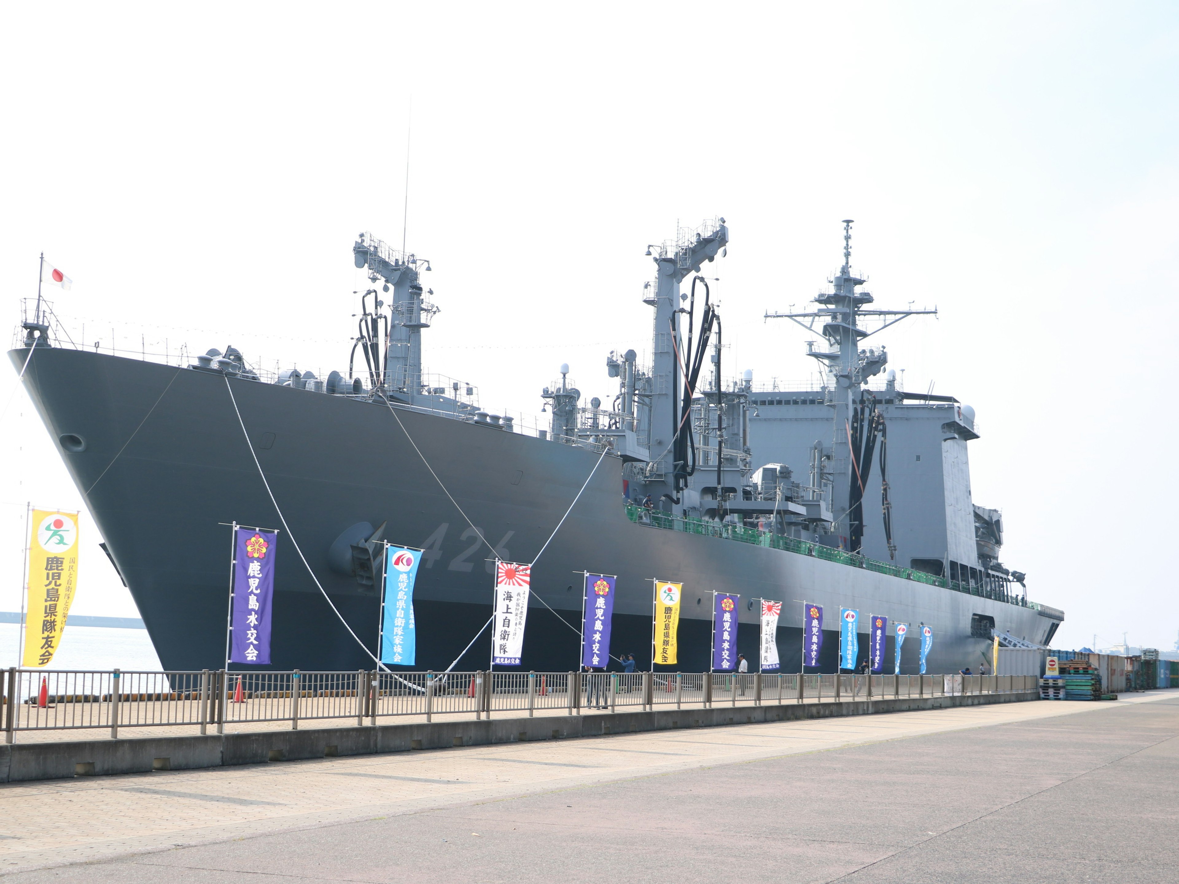 Un gran barco militar atracado en el puerto con banderas coloridas exhibidas