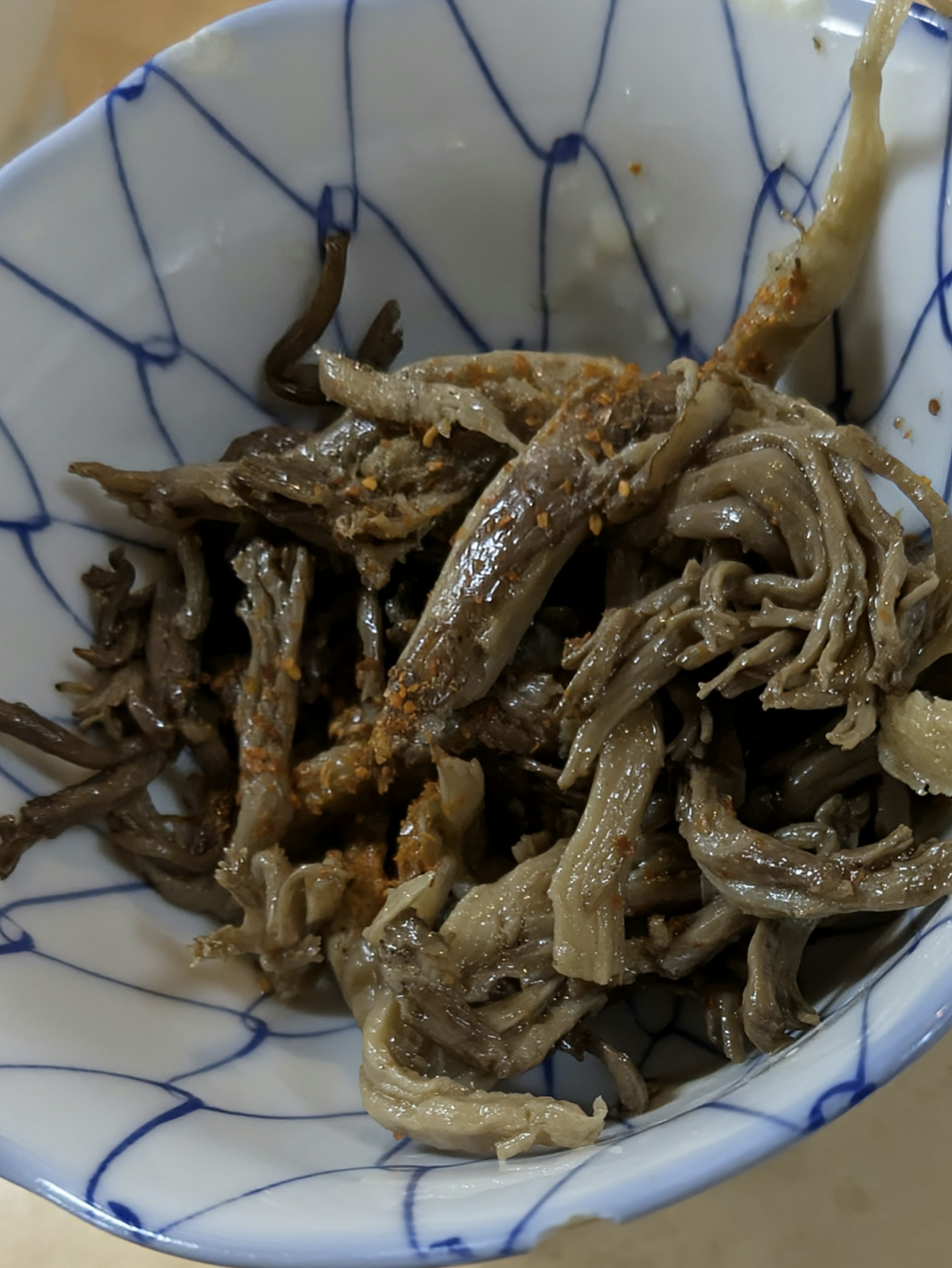 Small fish dish served in a white bowl with blue patterns