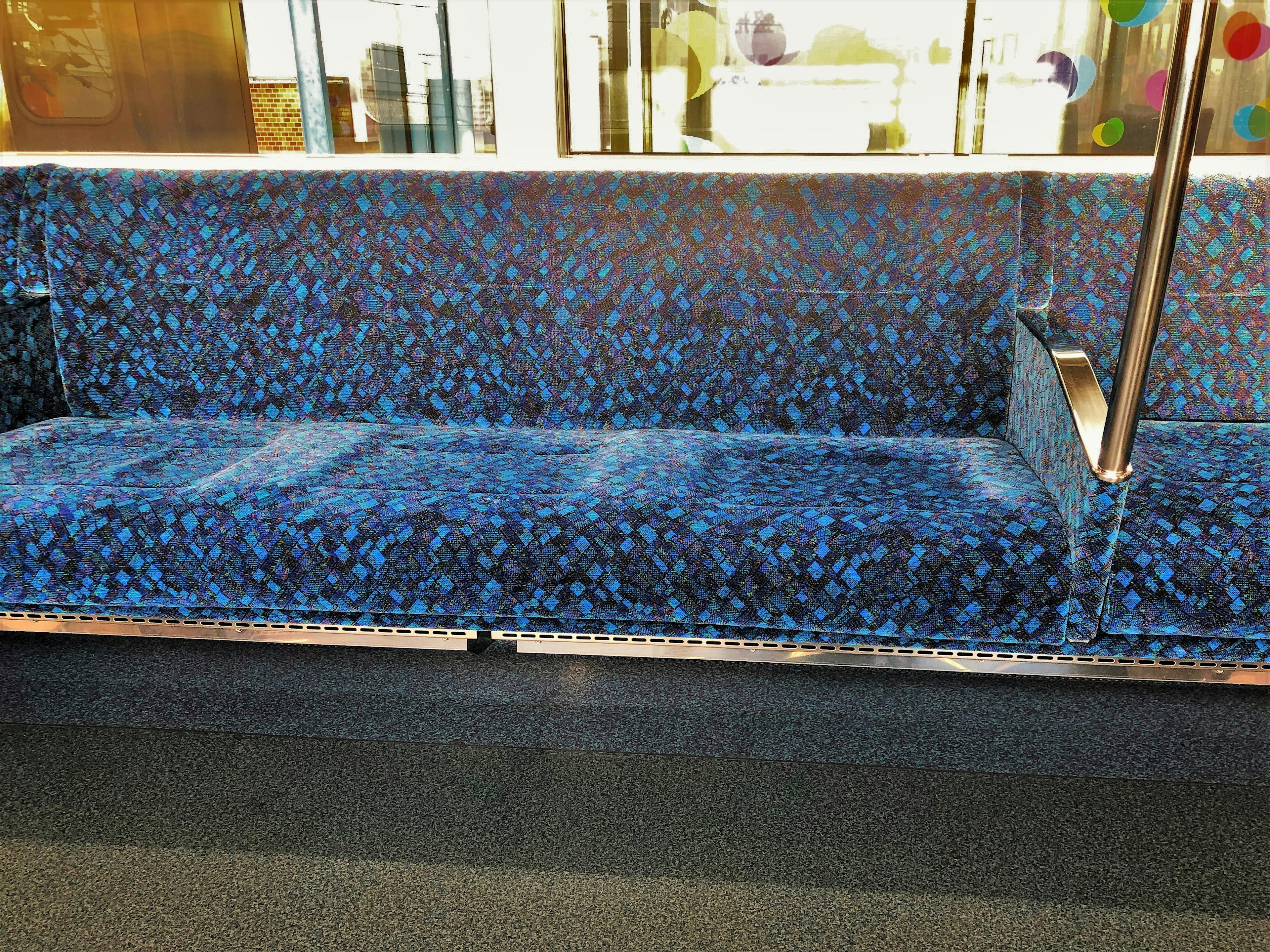 Asiento de patrón azul en un entorno de transporte público