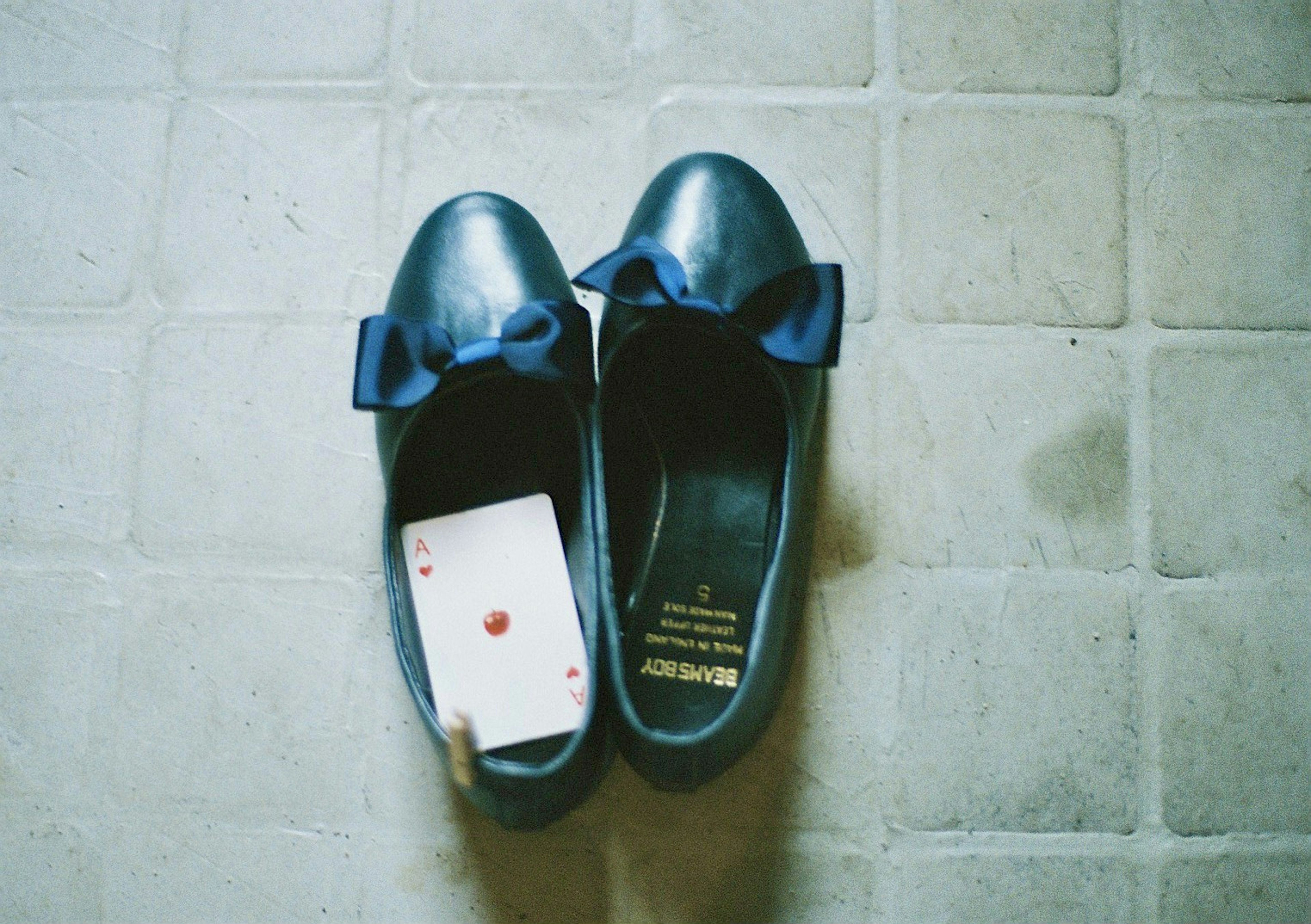 Pair of blue ballet flats with a playing card resting inside