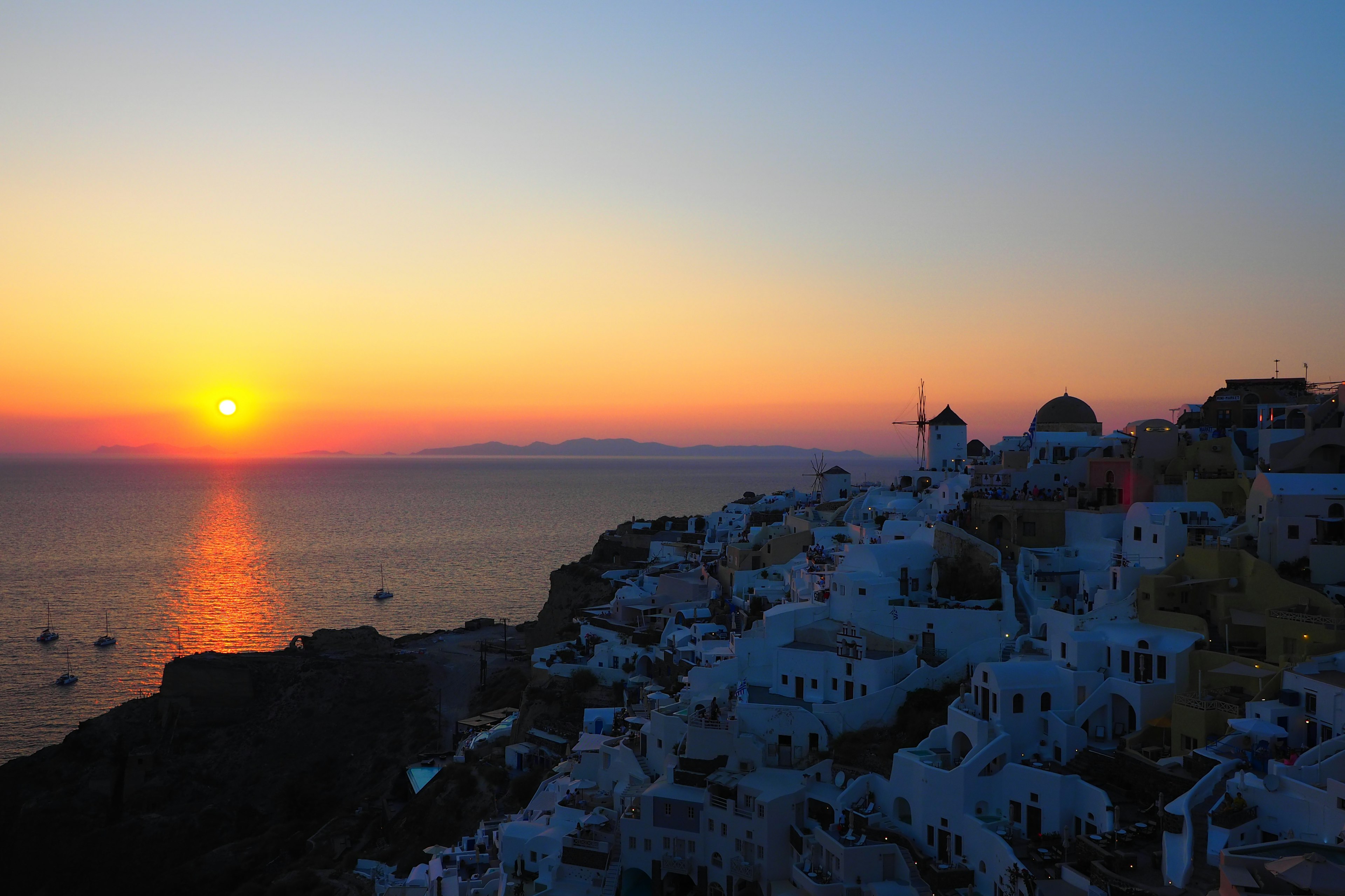 Wunderschöner Sonnenuntergang über Santorin mit weißen Gebäuden