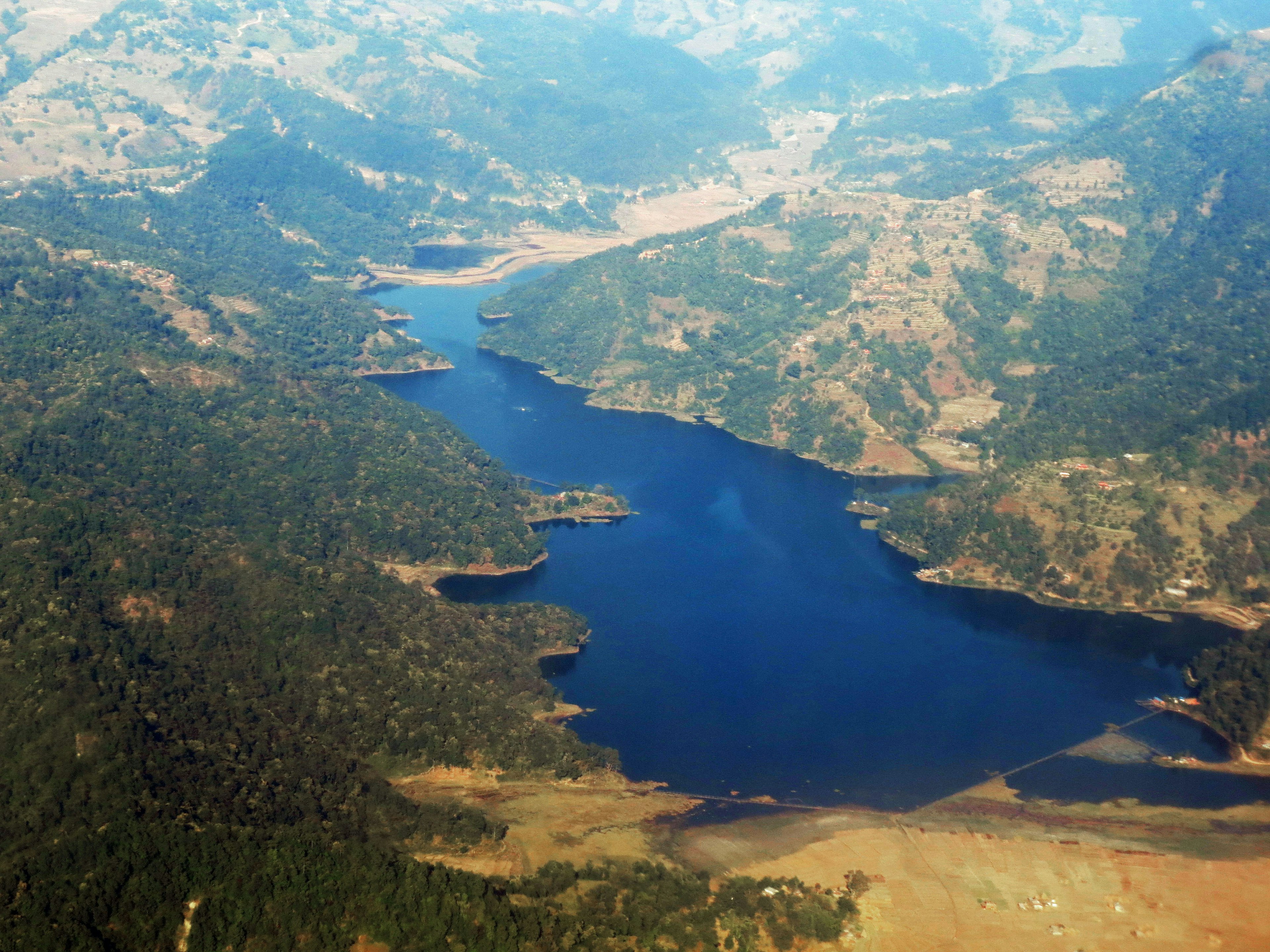 Aerial view of a serene lake surrounded by mountains and greenery