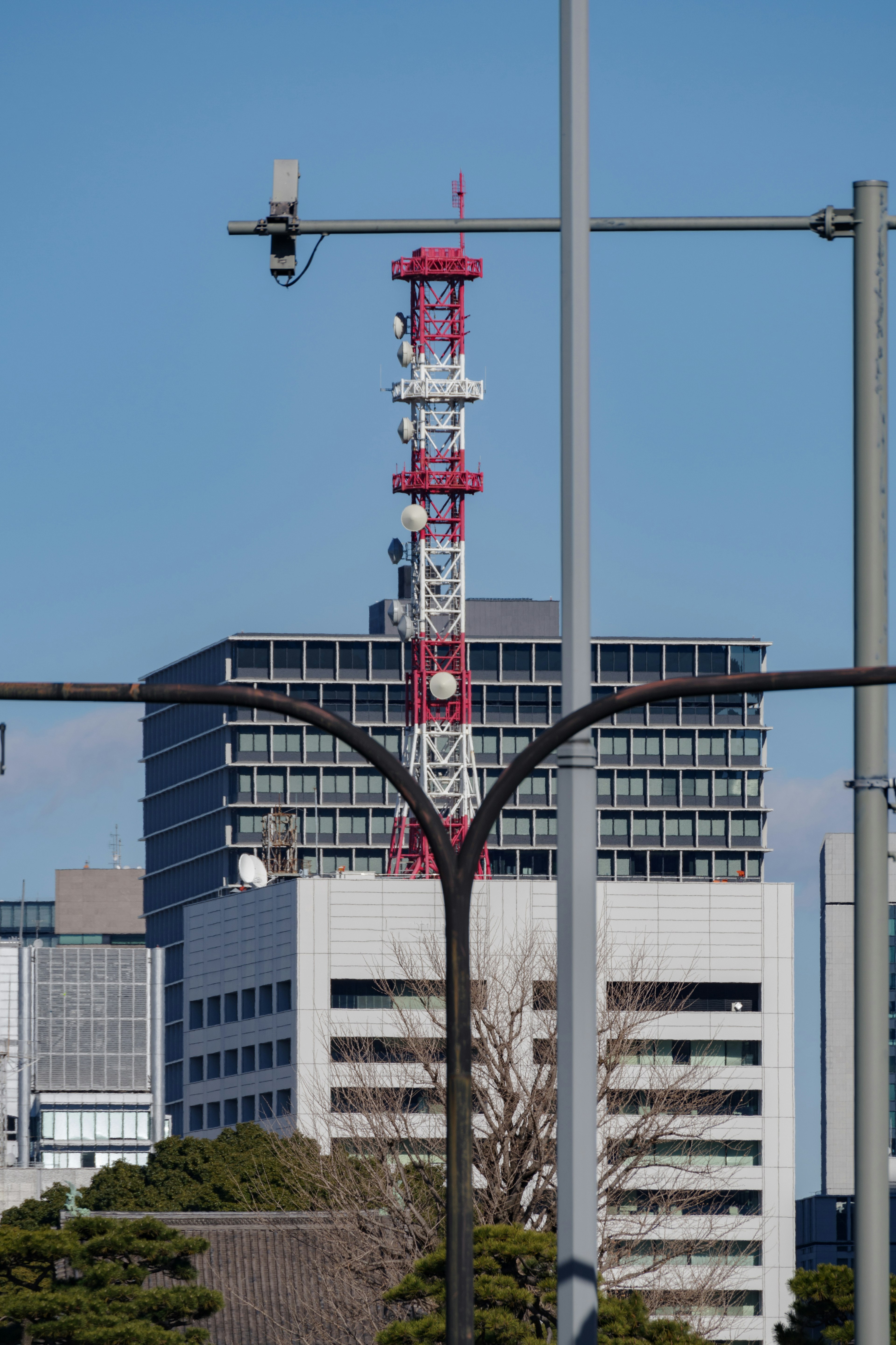 Panorama urbano con una torre di comunicazione rossa e bianca