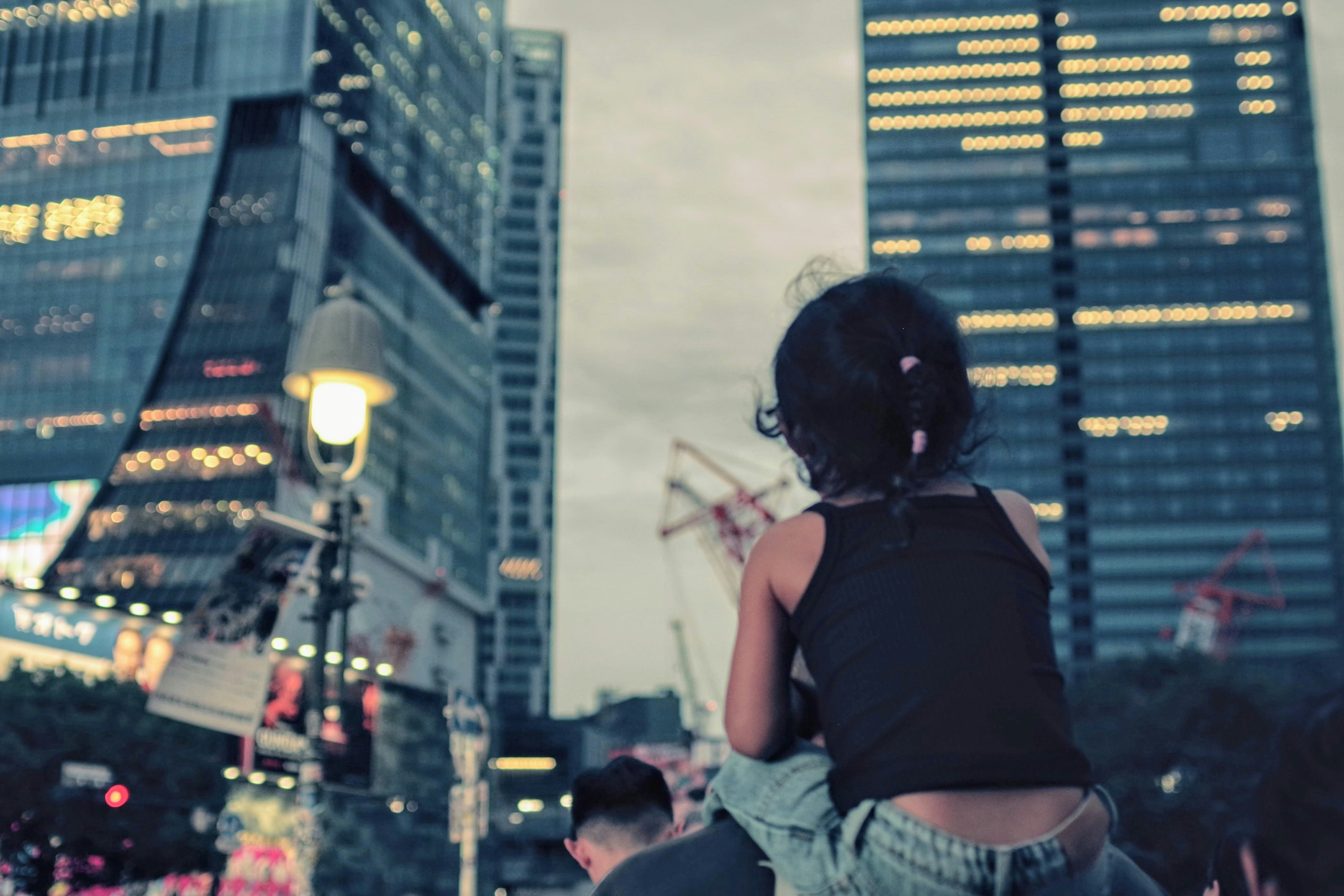 Child's back view against a nighttime cityscape