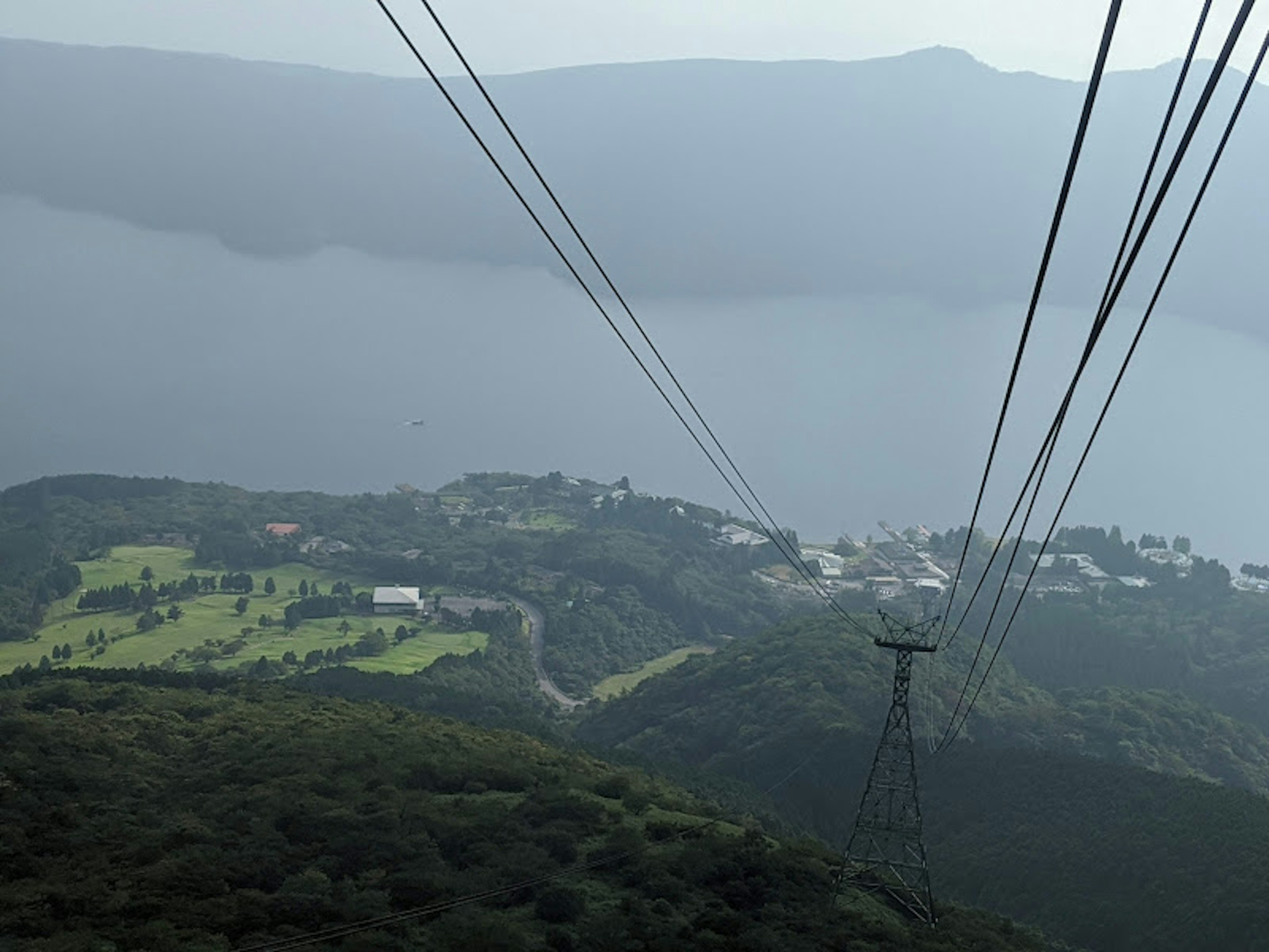 山の上からの風景とケーブルカーのワイヤーが見える