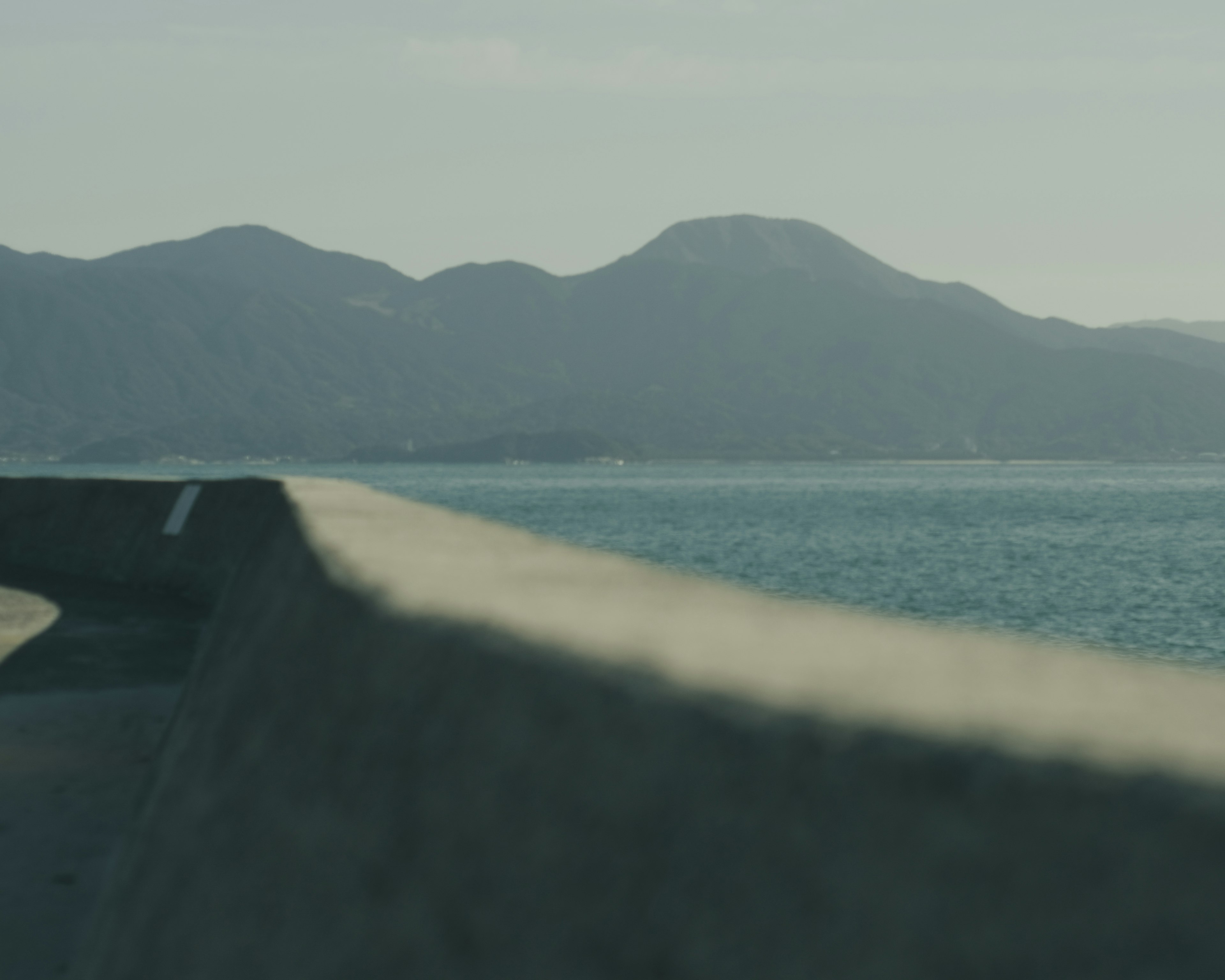 Imagen de una carretera serena junto al mar y las montañas