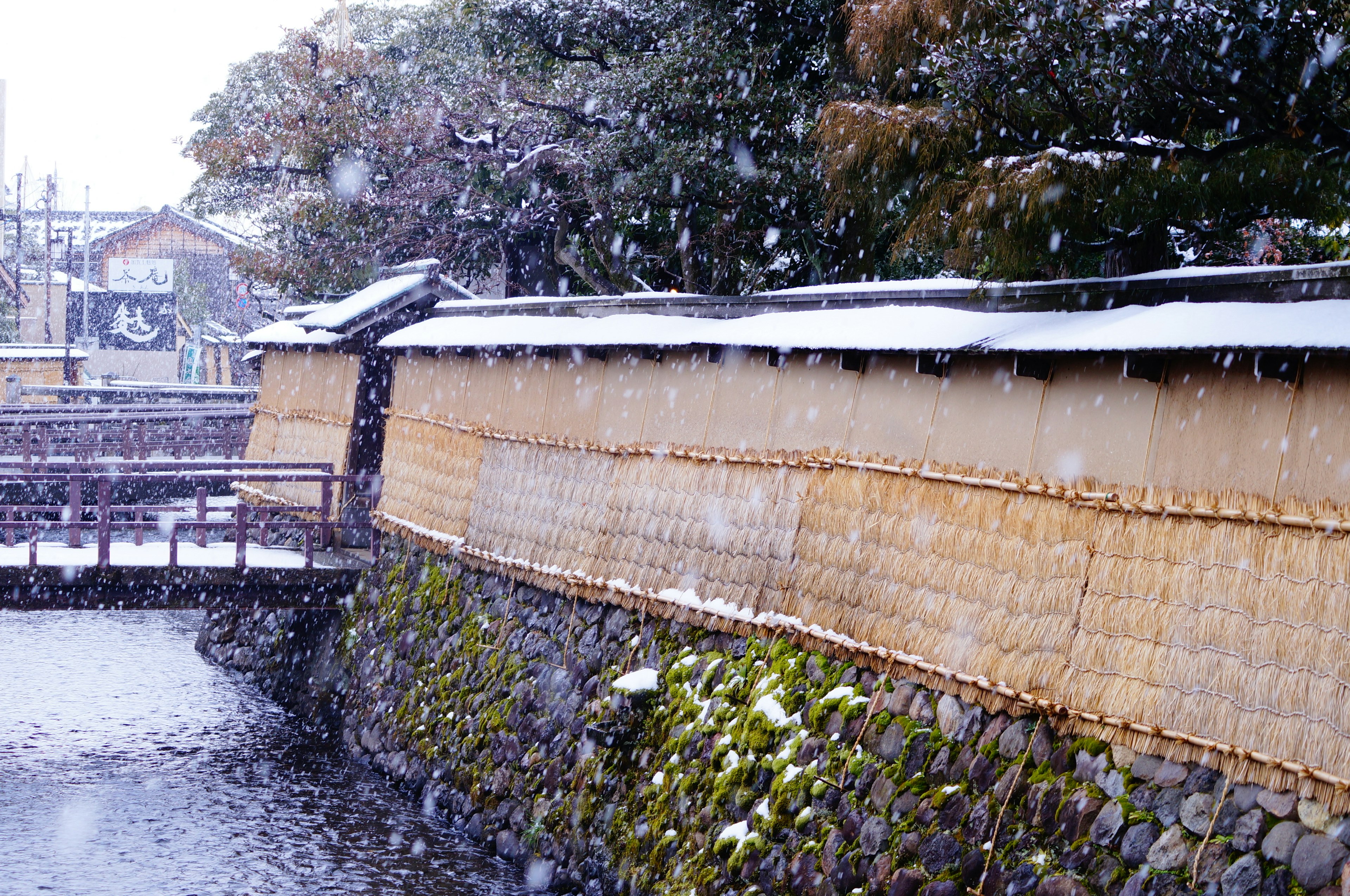 雪の中の伝統的な日本の壁と川の風景