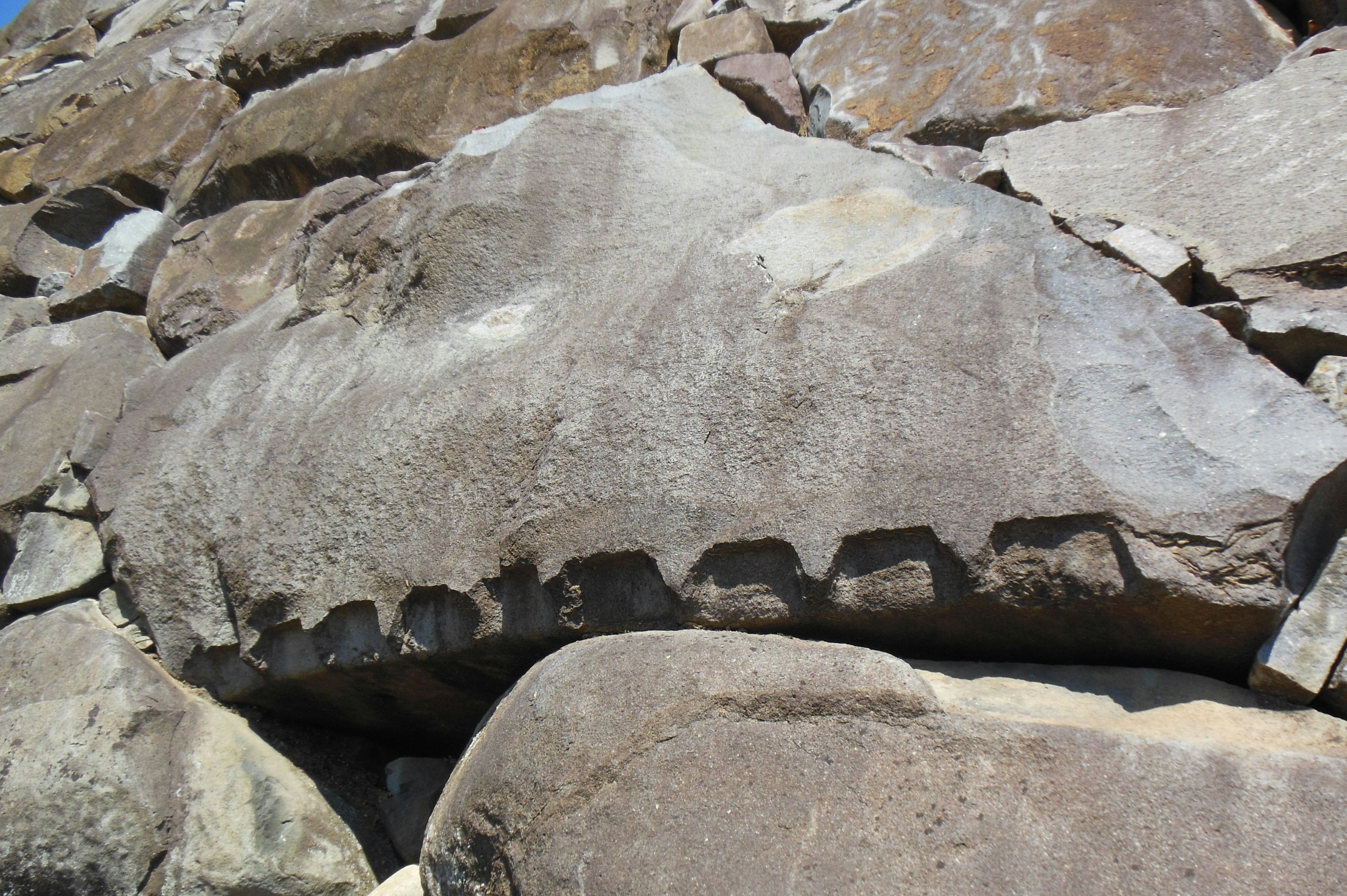 Grande sezione di roccia di un muro di pietra con scanalature e texture distintive