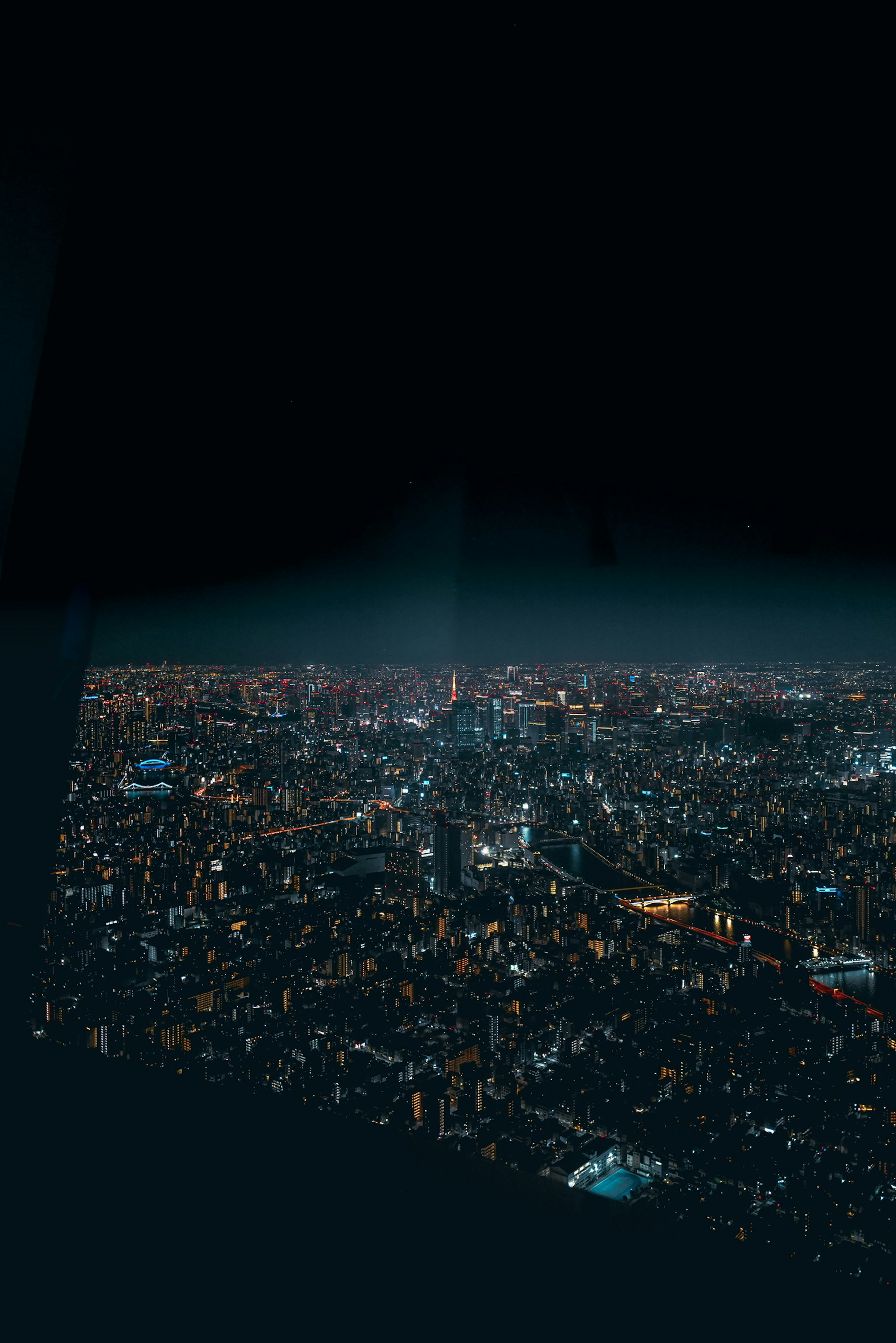 Aerial view of a city at night with glowing skyscraper lights