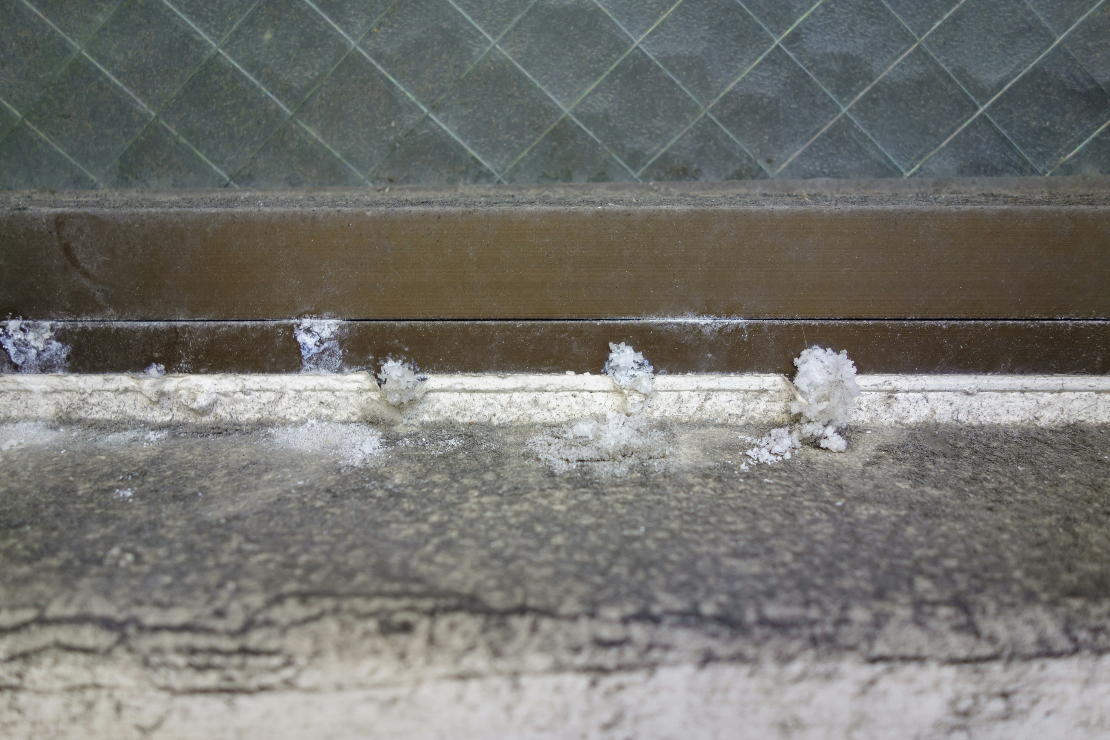 Schnee- und Eiskristalle, die sich auf einer Fensterbank angesammelt haben