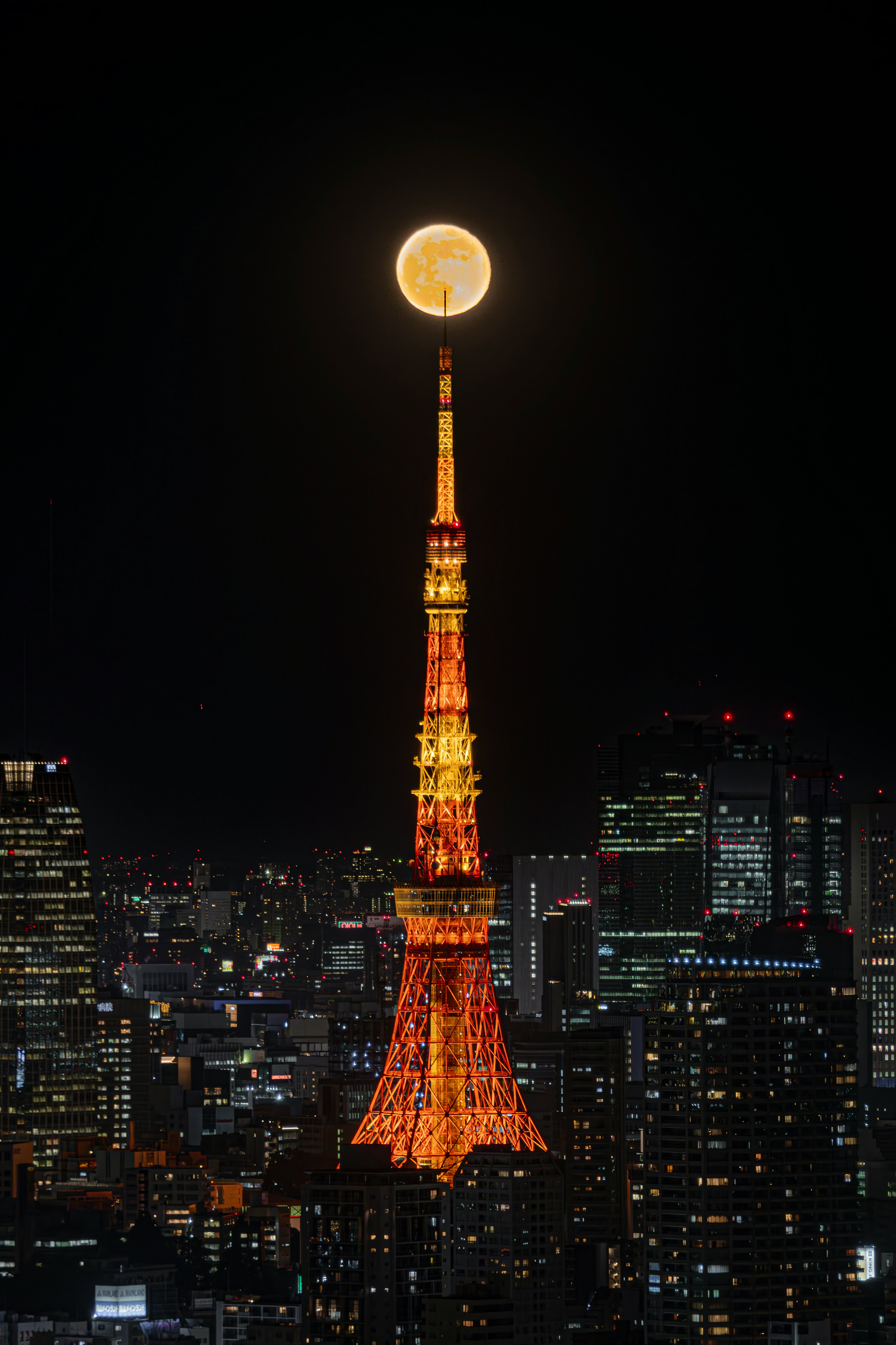 Menara Tokyo dengan bulan purnama di atas dan pemandangan kota di malam hari