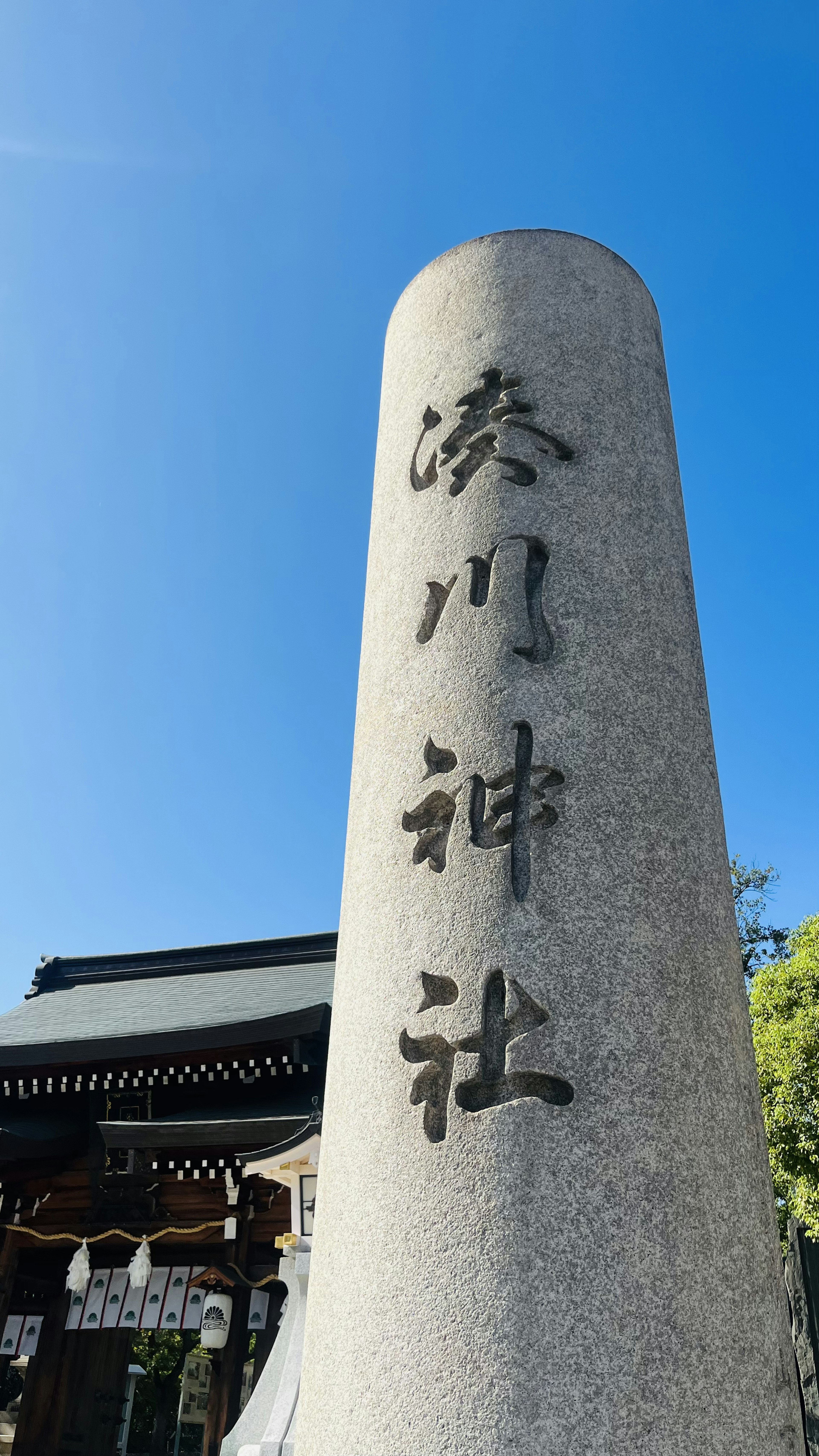 石の柱に刻まれた文字と青空の背景