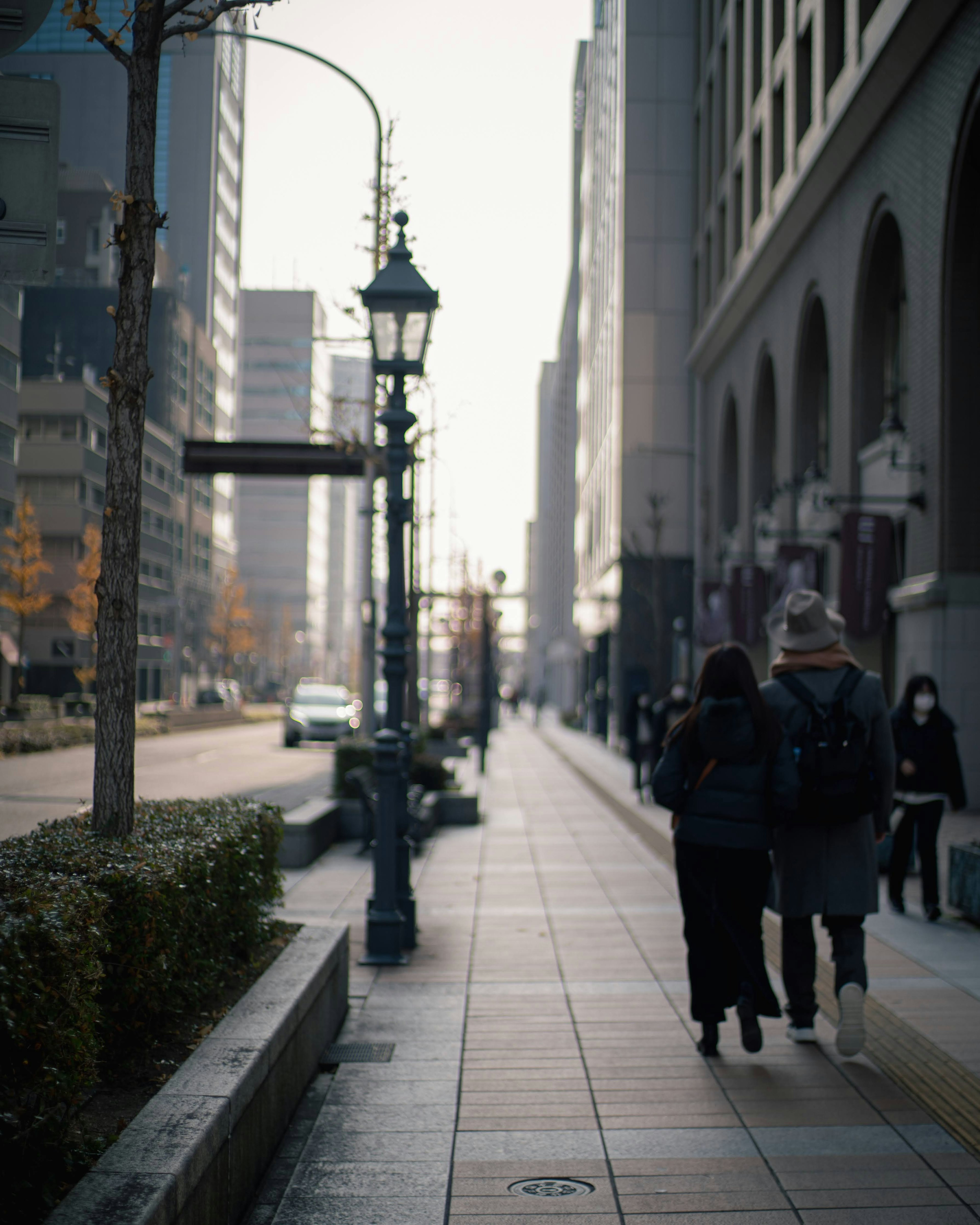 Urban street scene with people walking and a street lamp