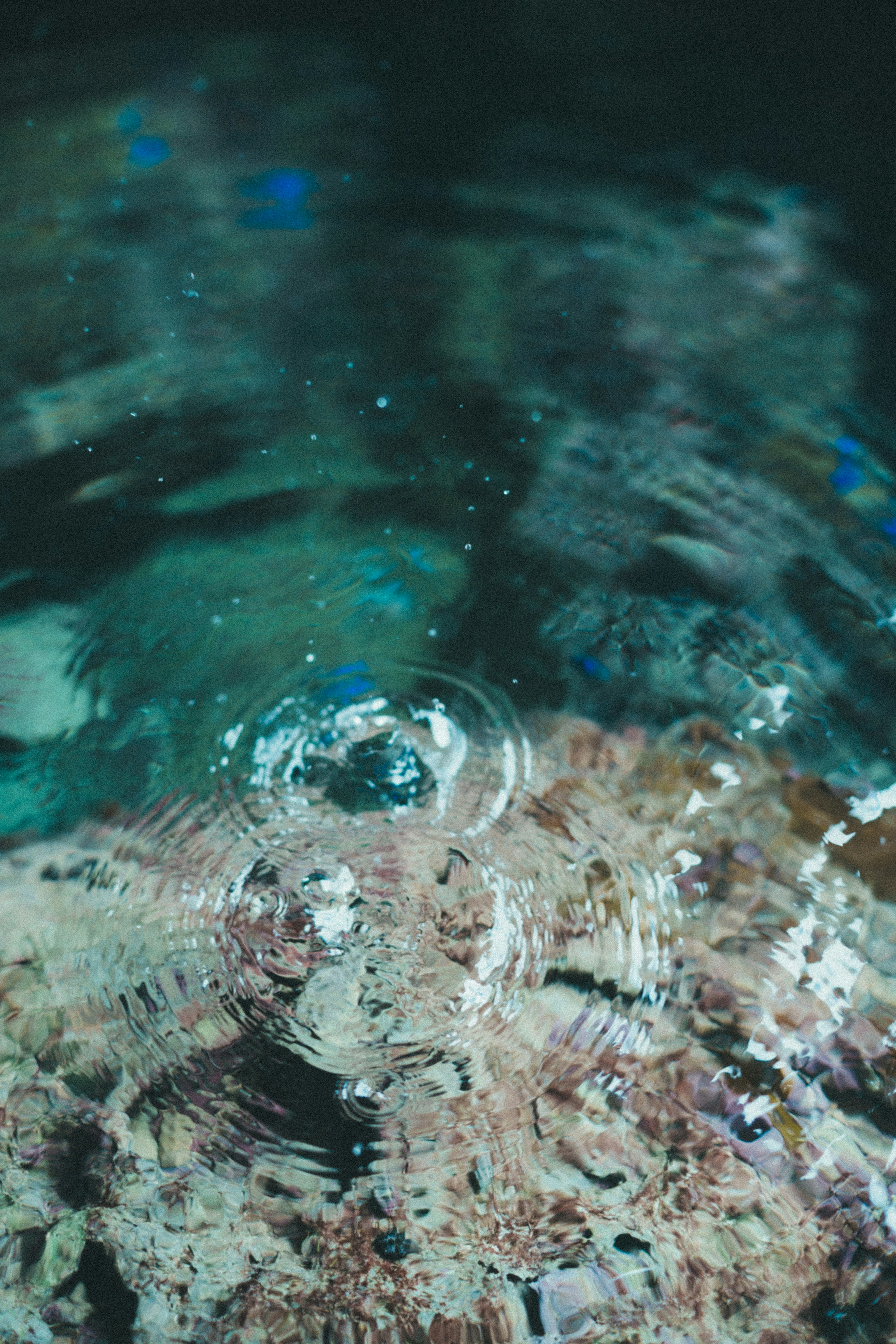 Ondas en la superficie del agua con patrones coloridos debajo