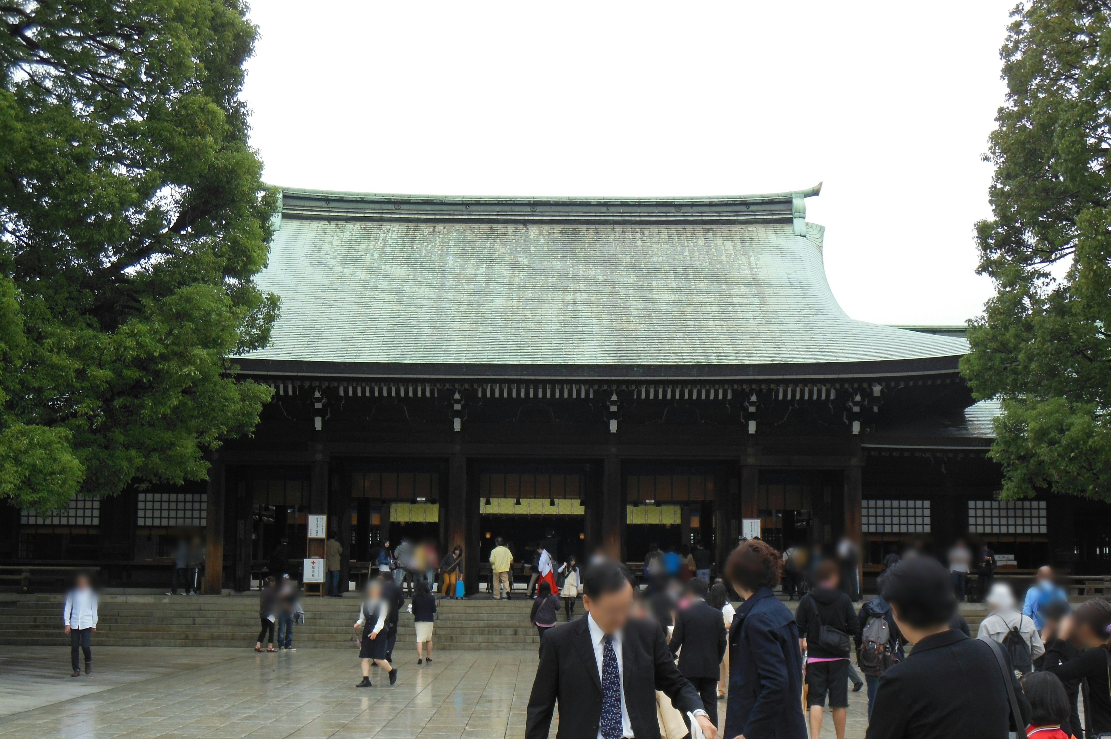 Meiji Shrine with a large roof and people walking around