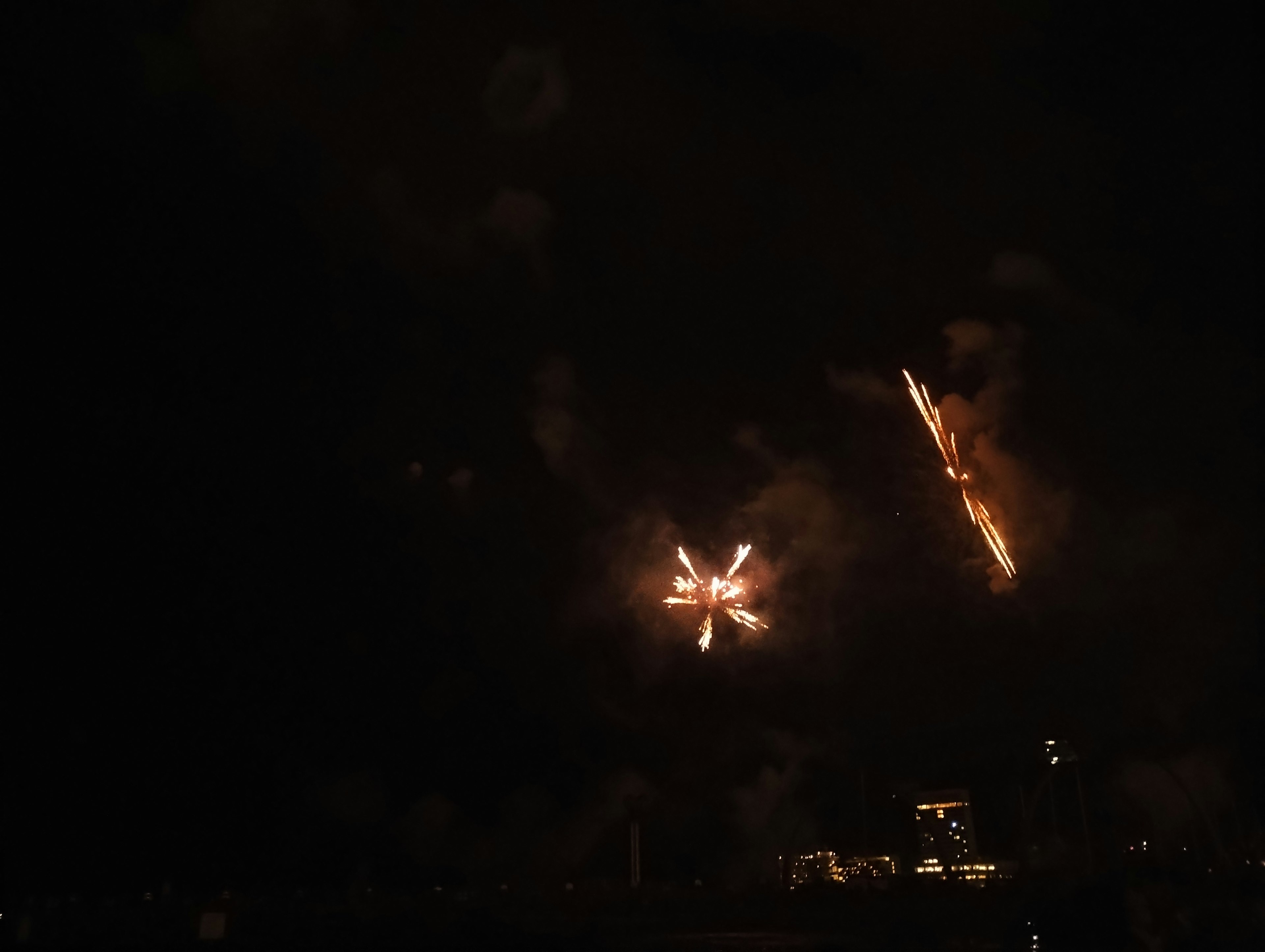 Explosion de feux d'artifice dans le ciel nocturne avec des traînées lumineuses