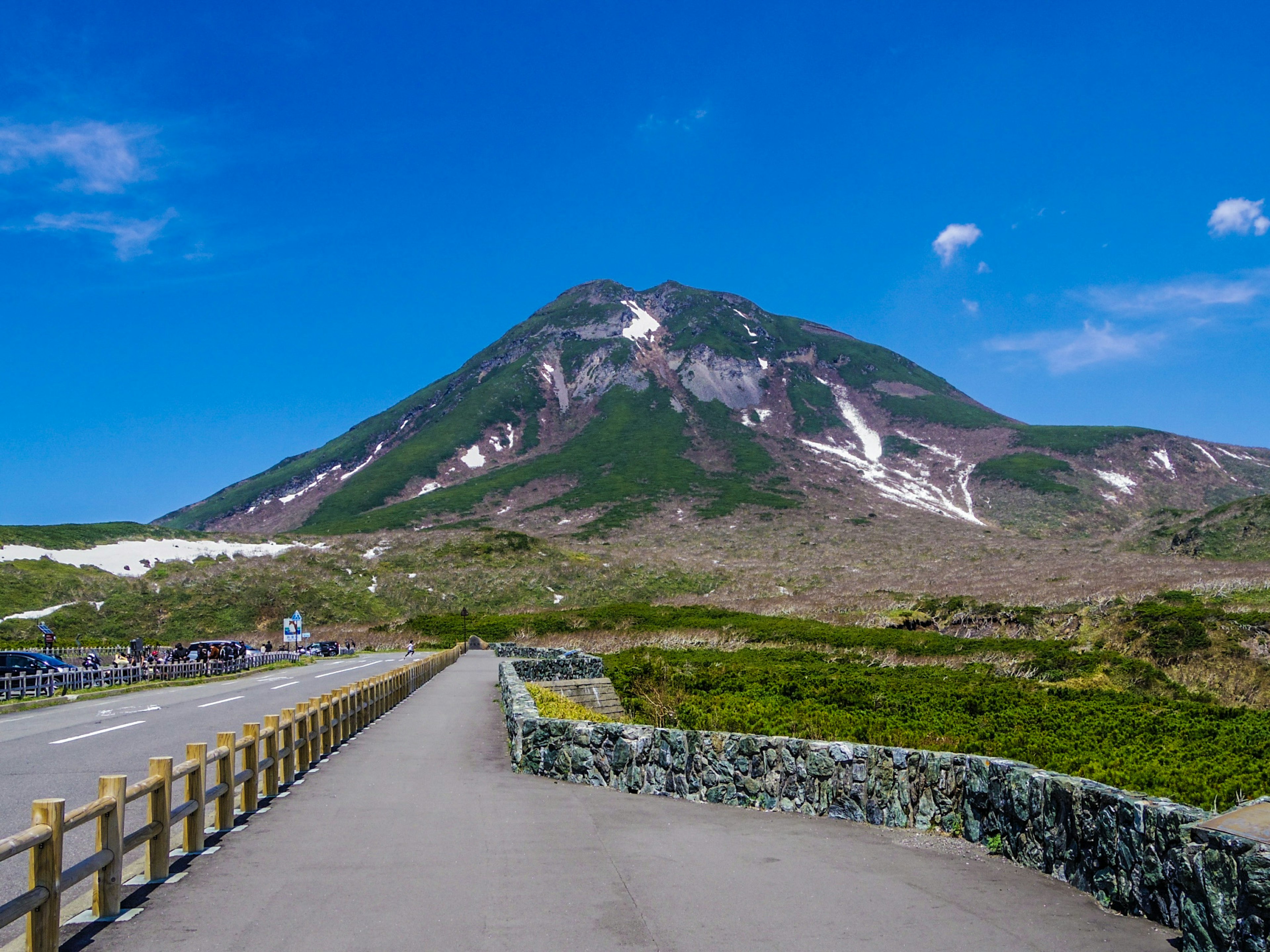 ทิวทัศน์ภูเขาใต้ท้องฟ้าสีฟ้าสดใสพร้อมถนน