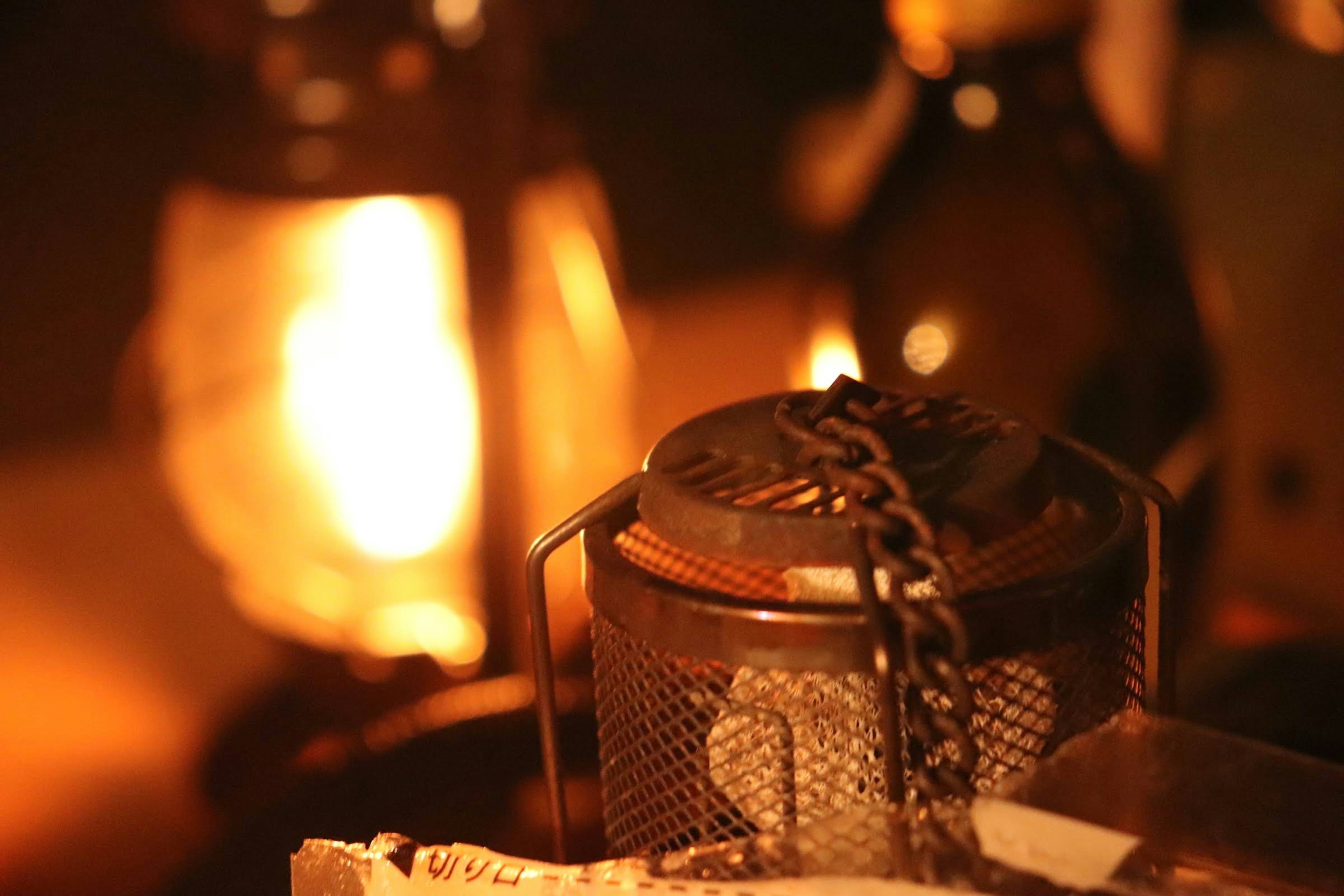 A dimly lit scene featuring an oil lamp and a metallic container