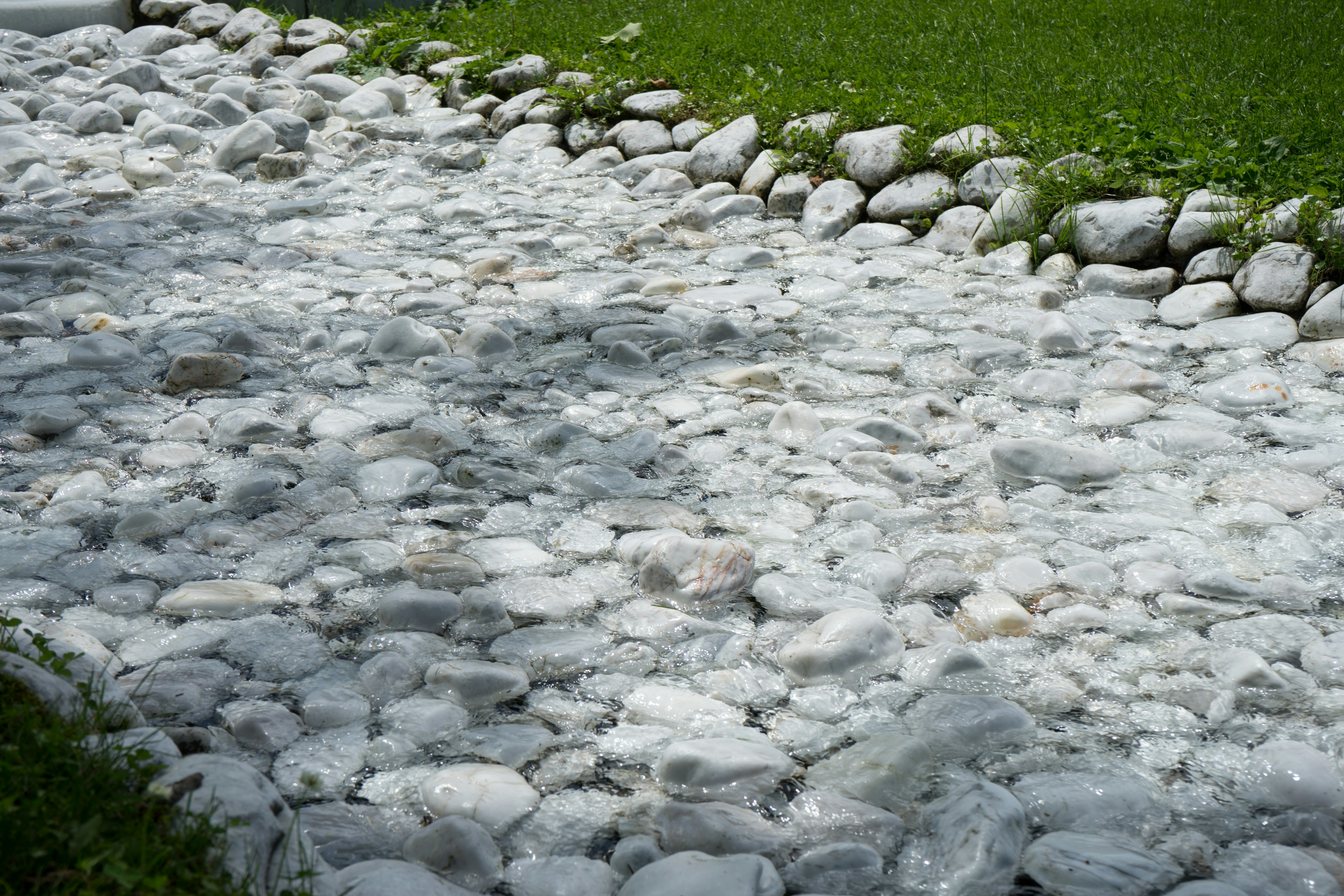 A pathway made of white stones bordered by green grass