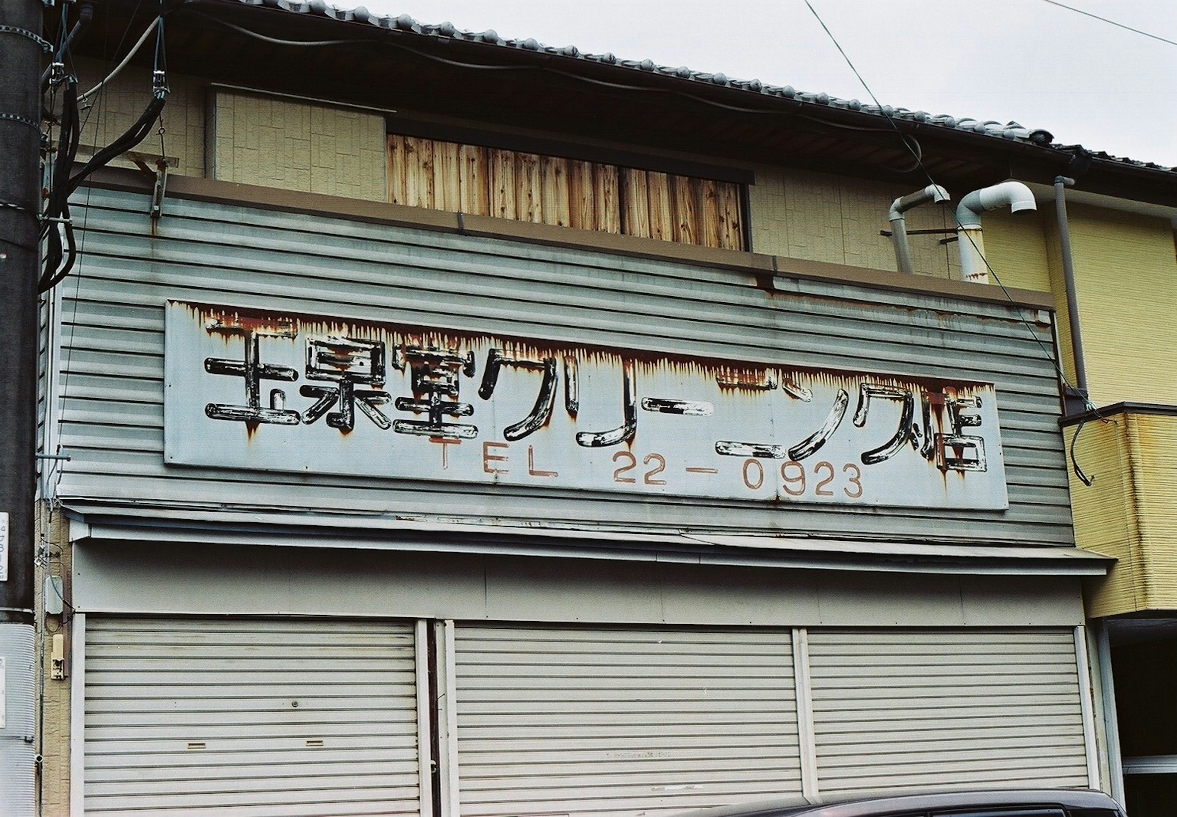 Exterior of a factory with an old rusted sign