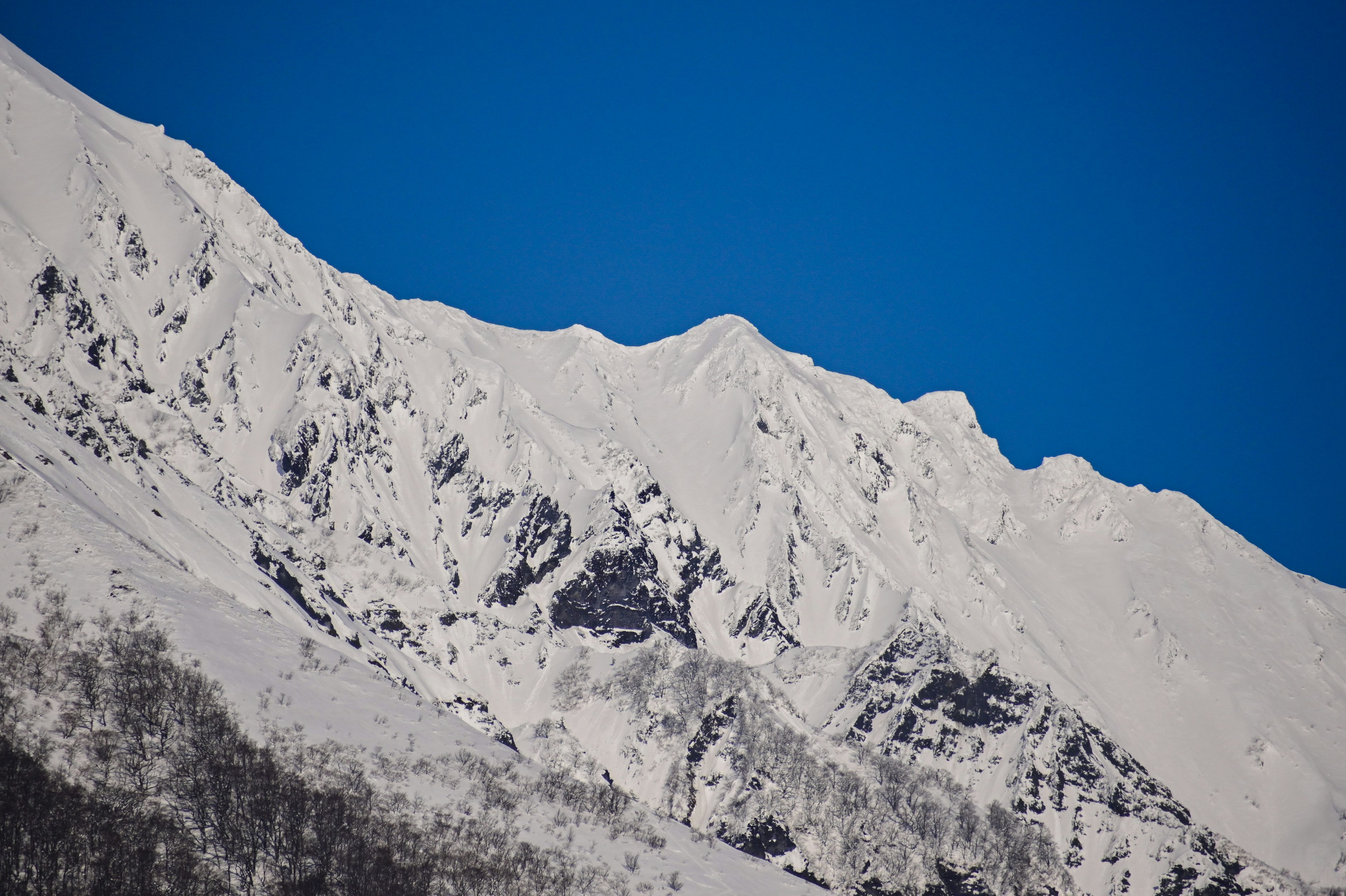 Snow-covered mountain peaks against a clear blue sky