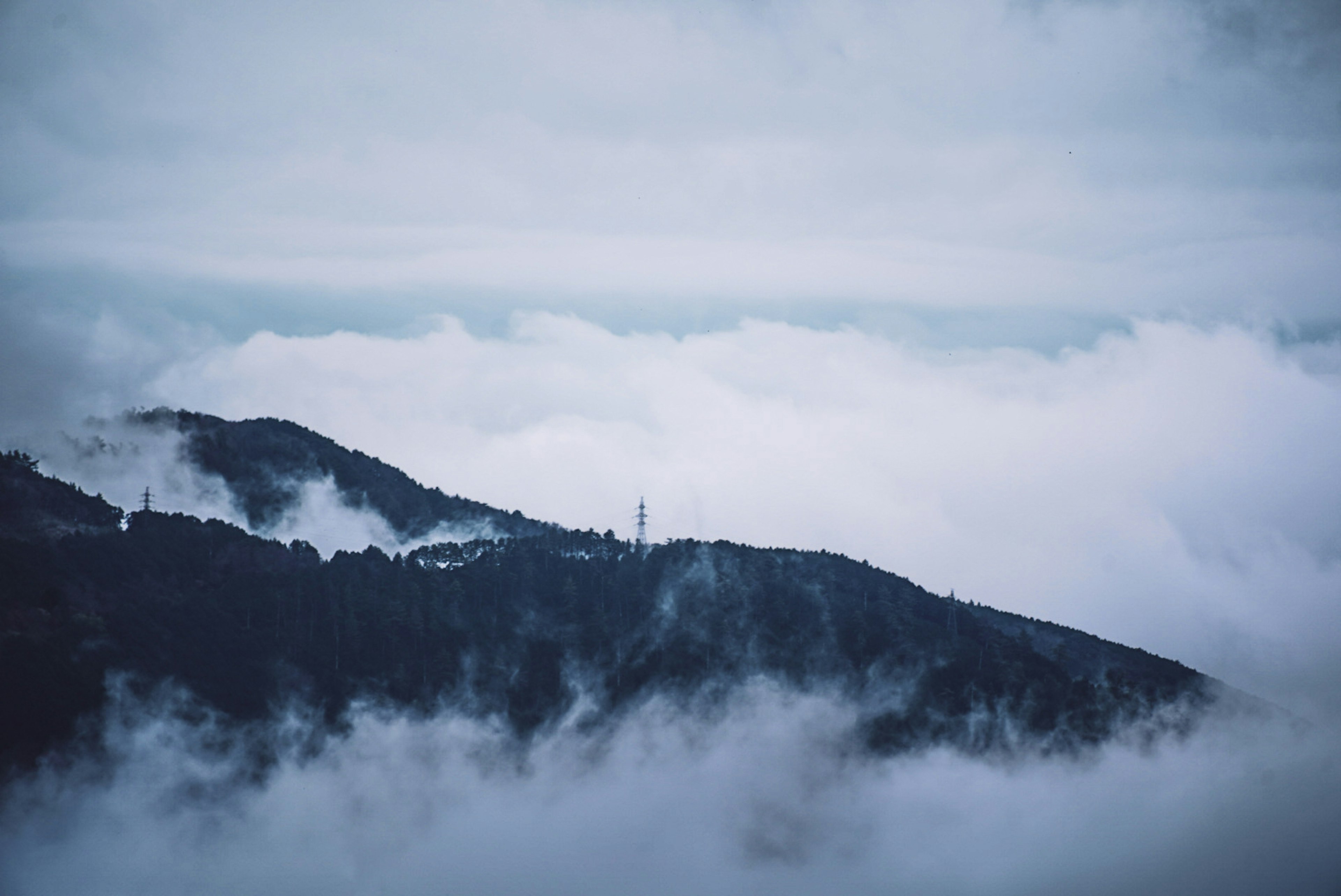 雲海に覆われた山の風景、青い色調の空