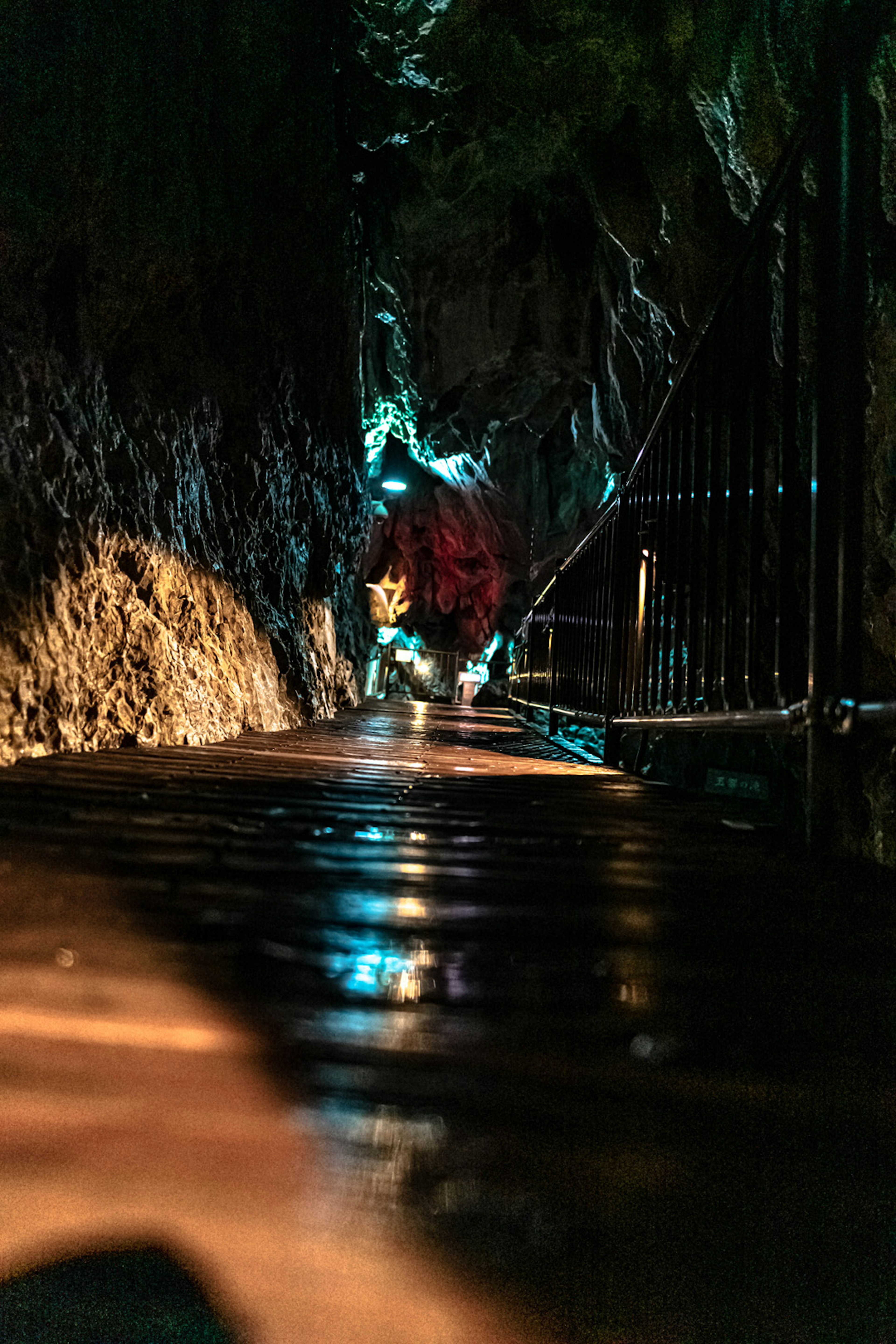 Reflejos en charcos a lo largo de un camino de cueva tenuemente iluminado