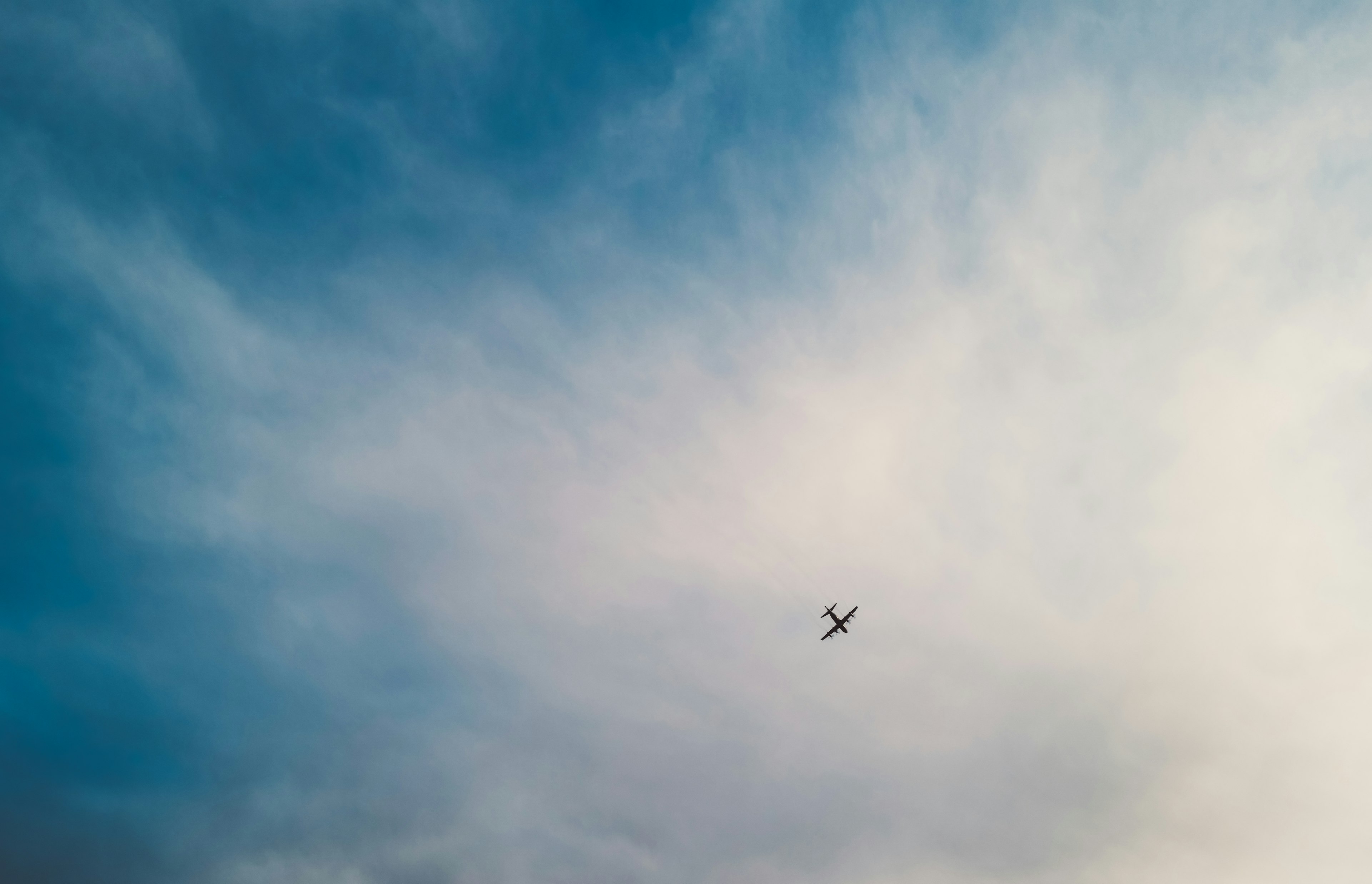 Aereo che vola in un cielo blu con nuvole leggere