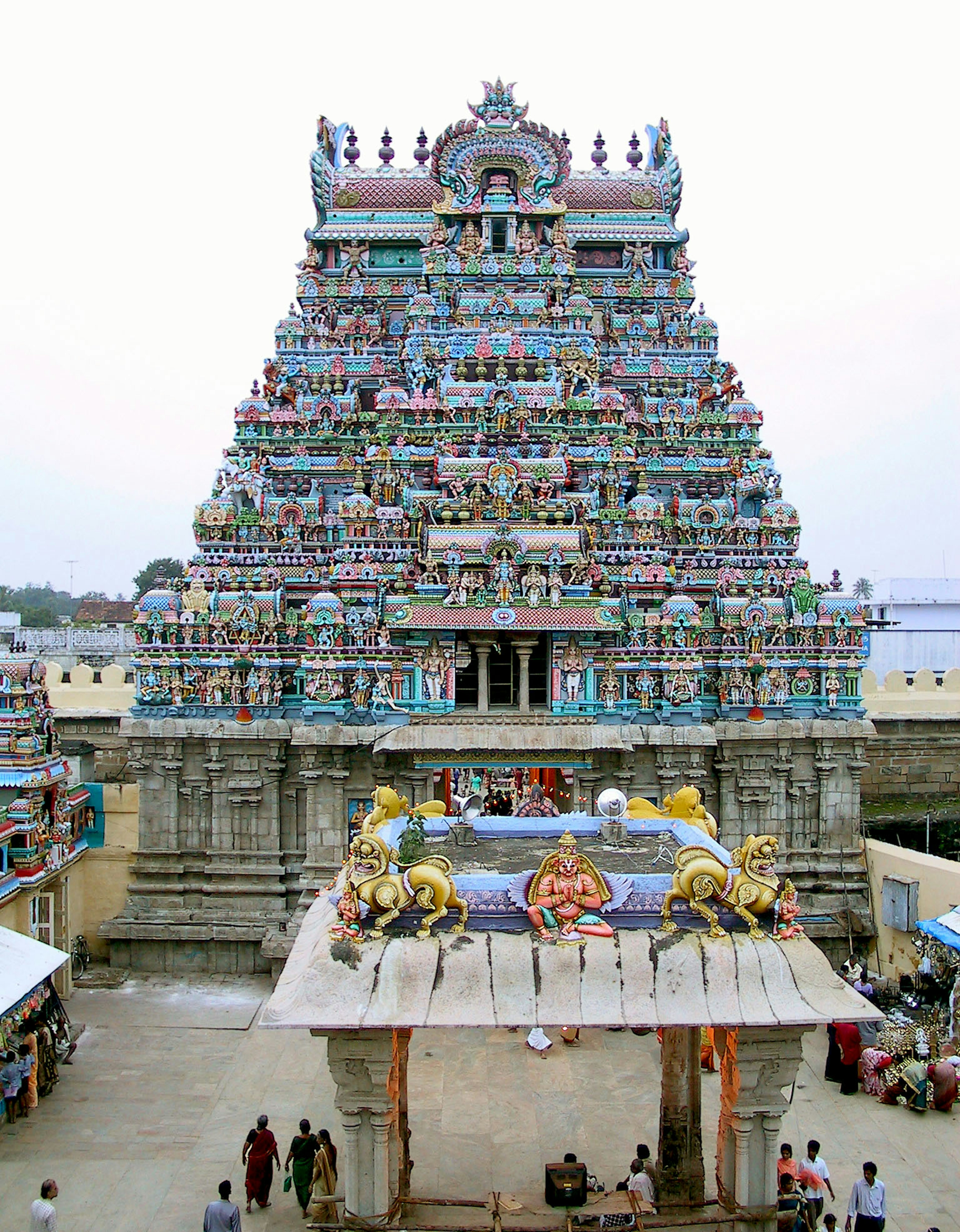 A temple tower adorned with colorful sculptures and surrounding landscape