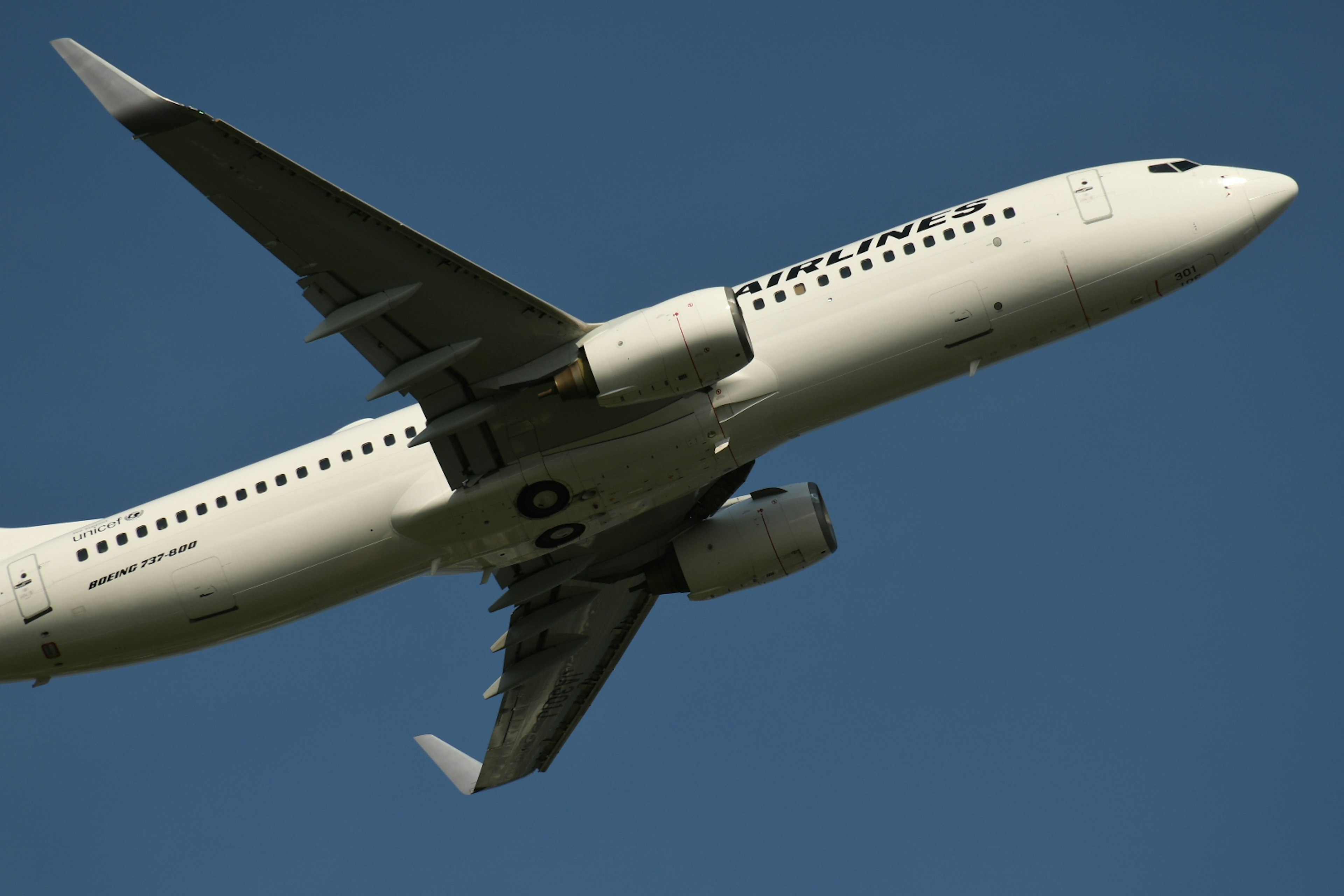 Seitenansicht eines Flugzeugs, das gegen einen blauen Himmel fliegt