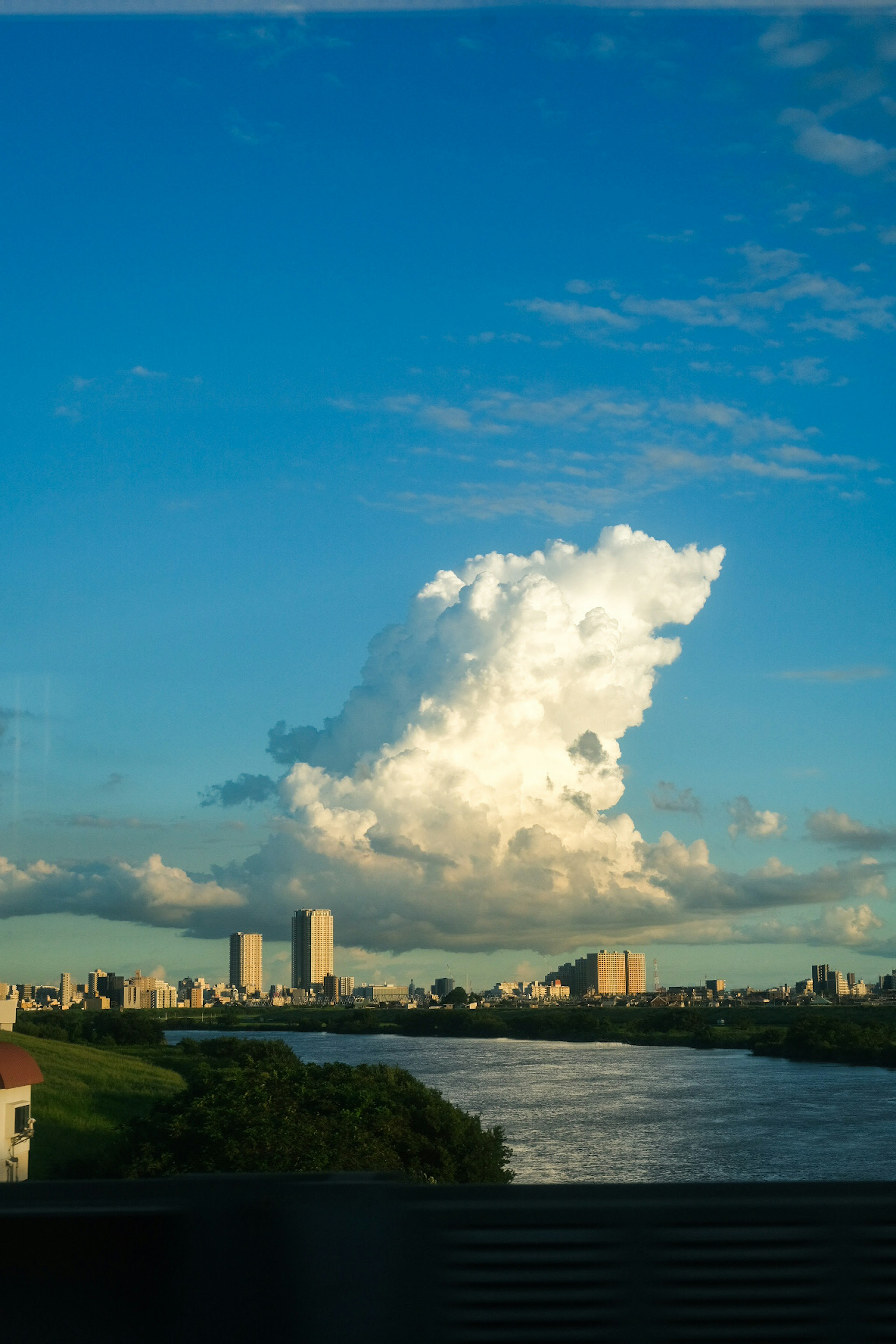 Stadtansicht mit einer großen weißen Wolke vor blauem Himmel