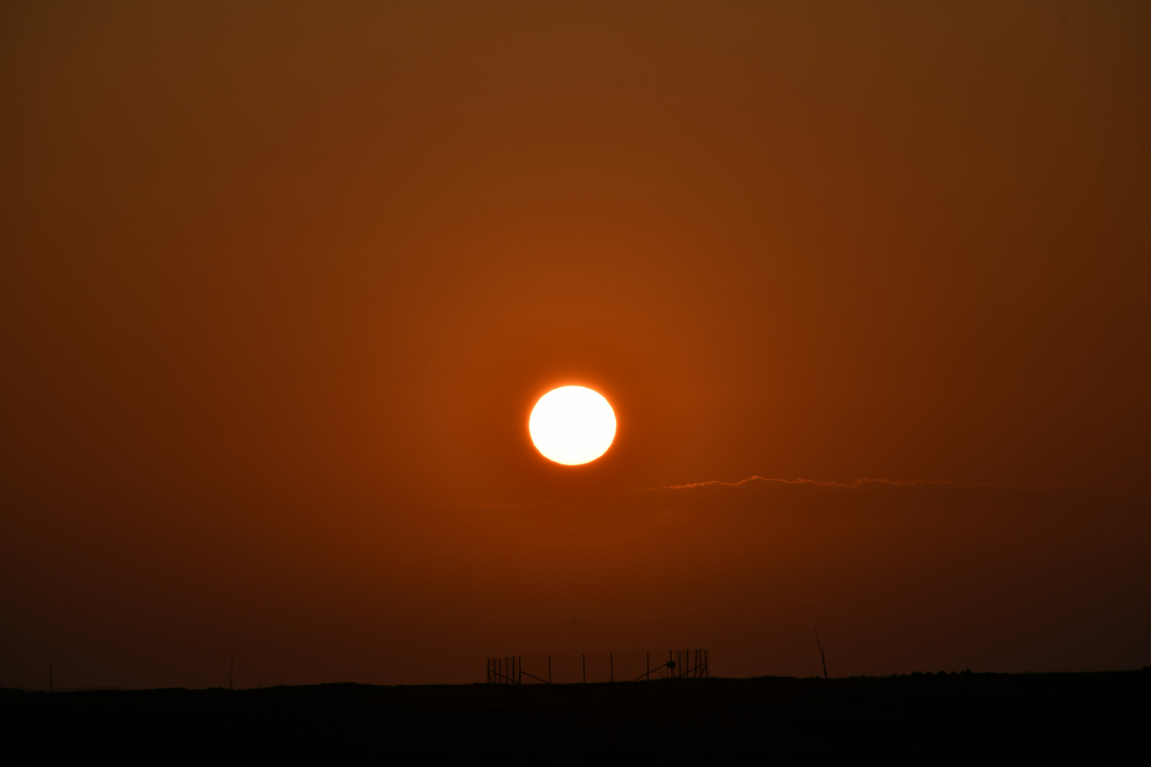 Atardecer con cielo naranja y un sol prominente