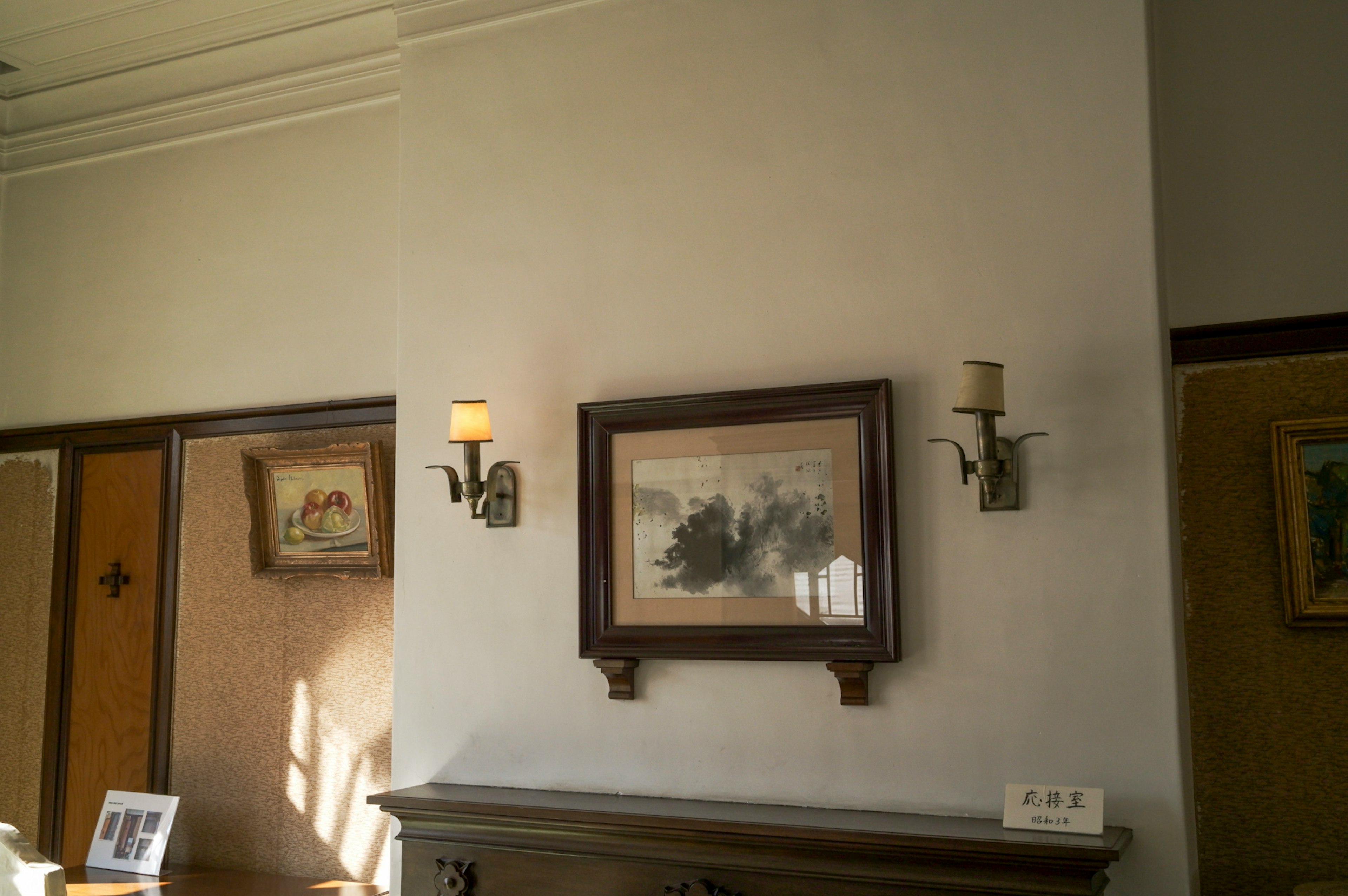 Interno con un dipinto appeso al muro e candelabri