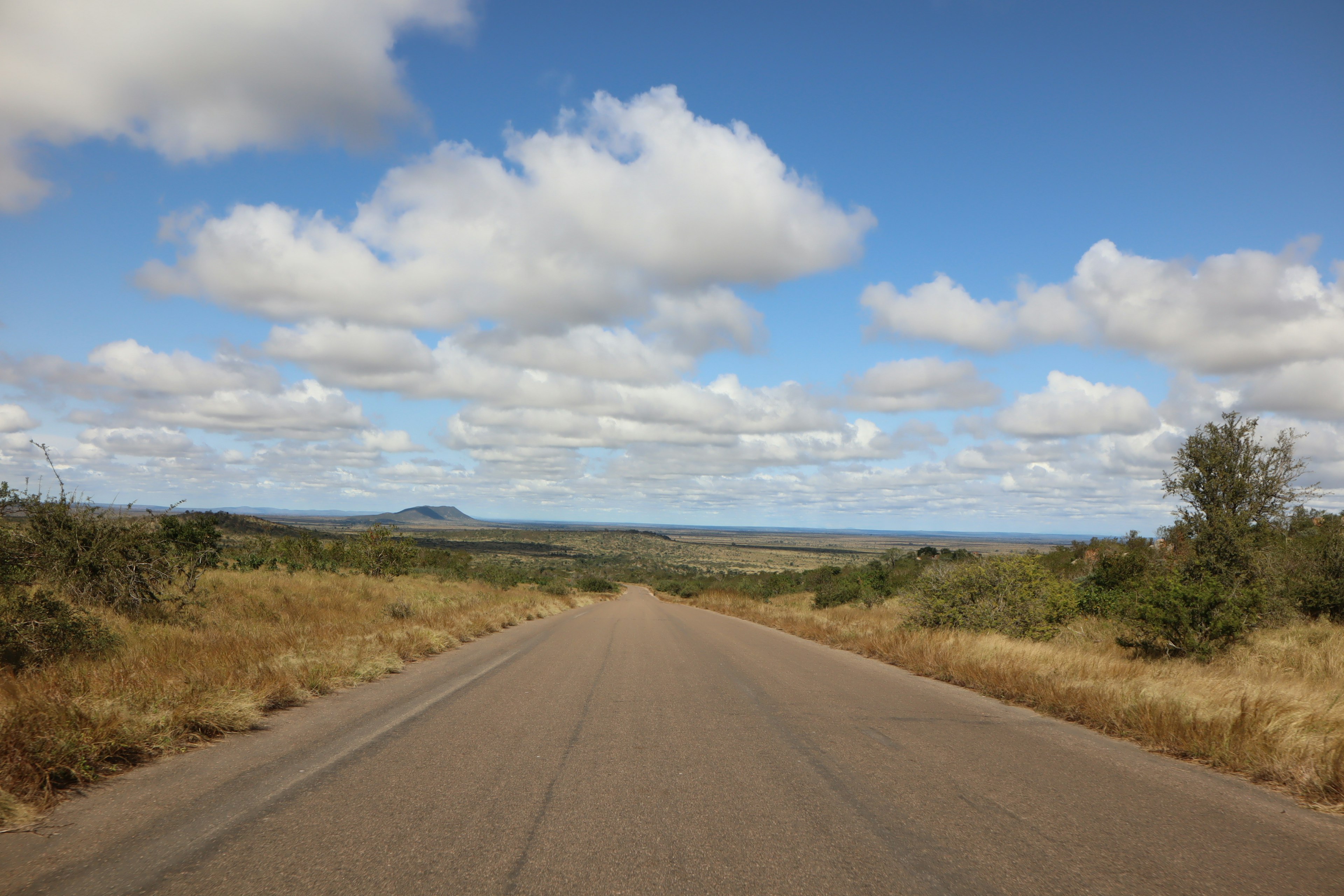 Paisaje de carretera abierta bajo un cielo azul con nubes