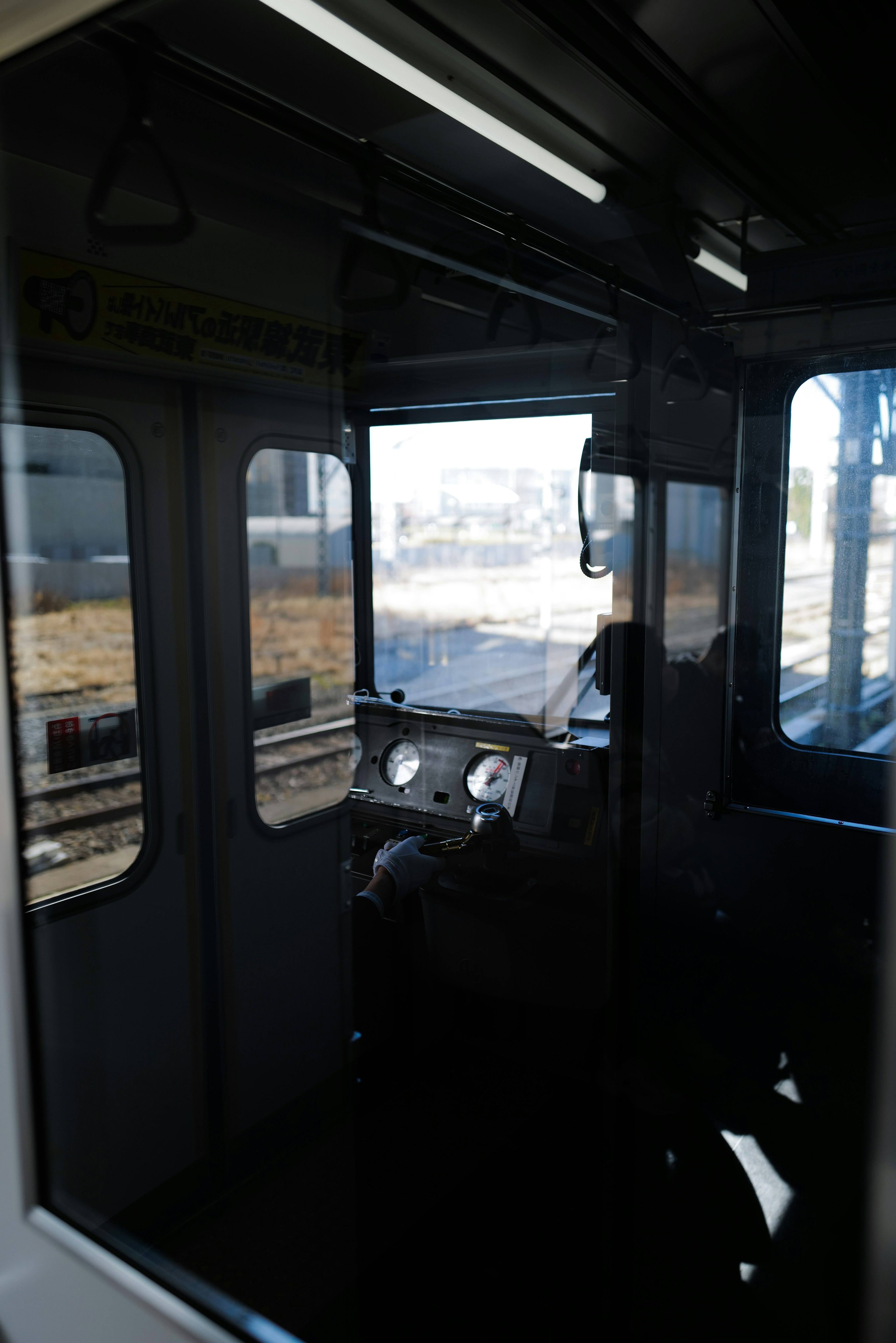 Interior view of a train driver's cab showing controls and an outside view through the window