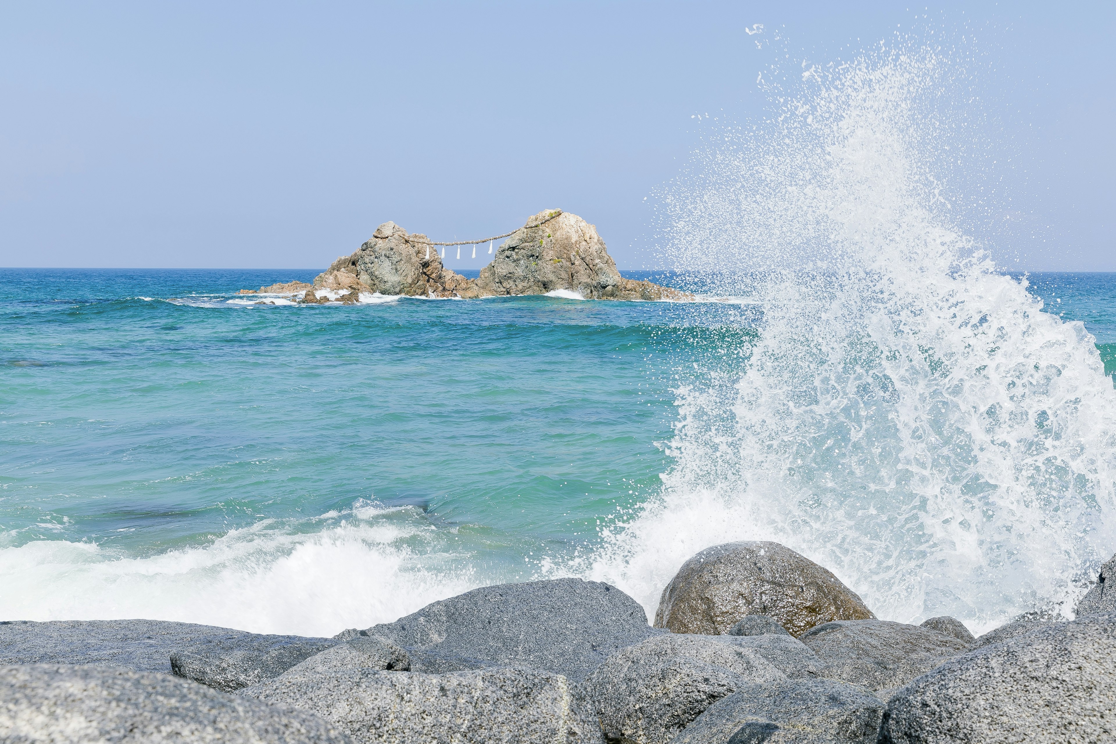 Escena costera con olas salpicando contra las rocas