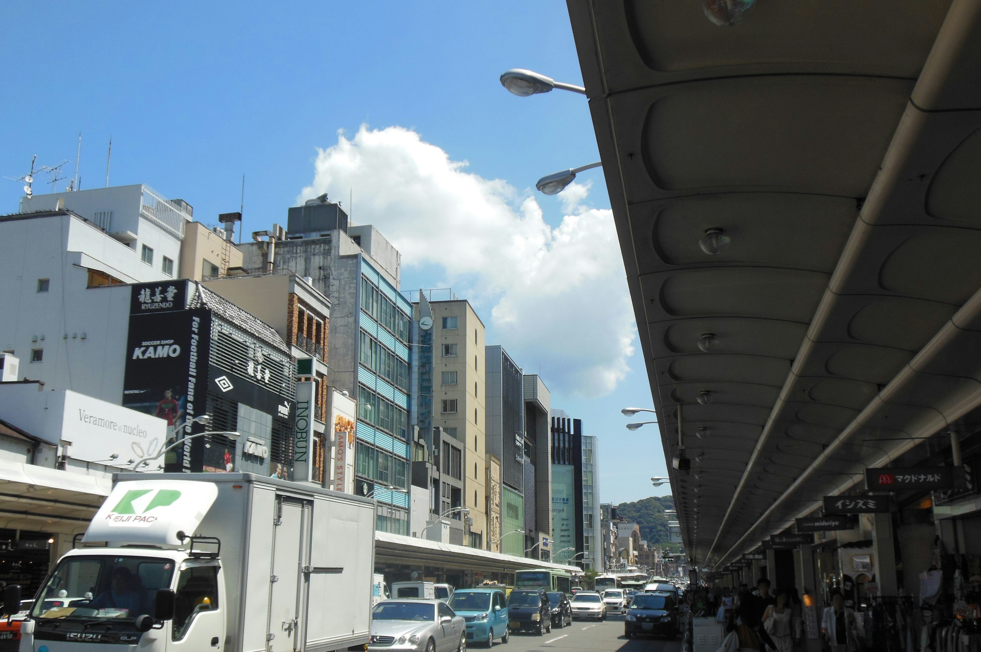 Paesaggio urbano con edifici e camion sotto un cielo blu