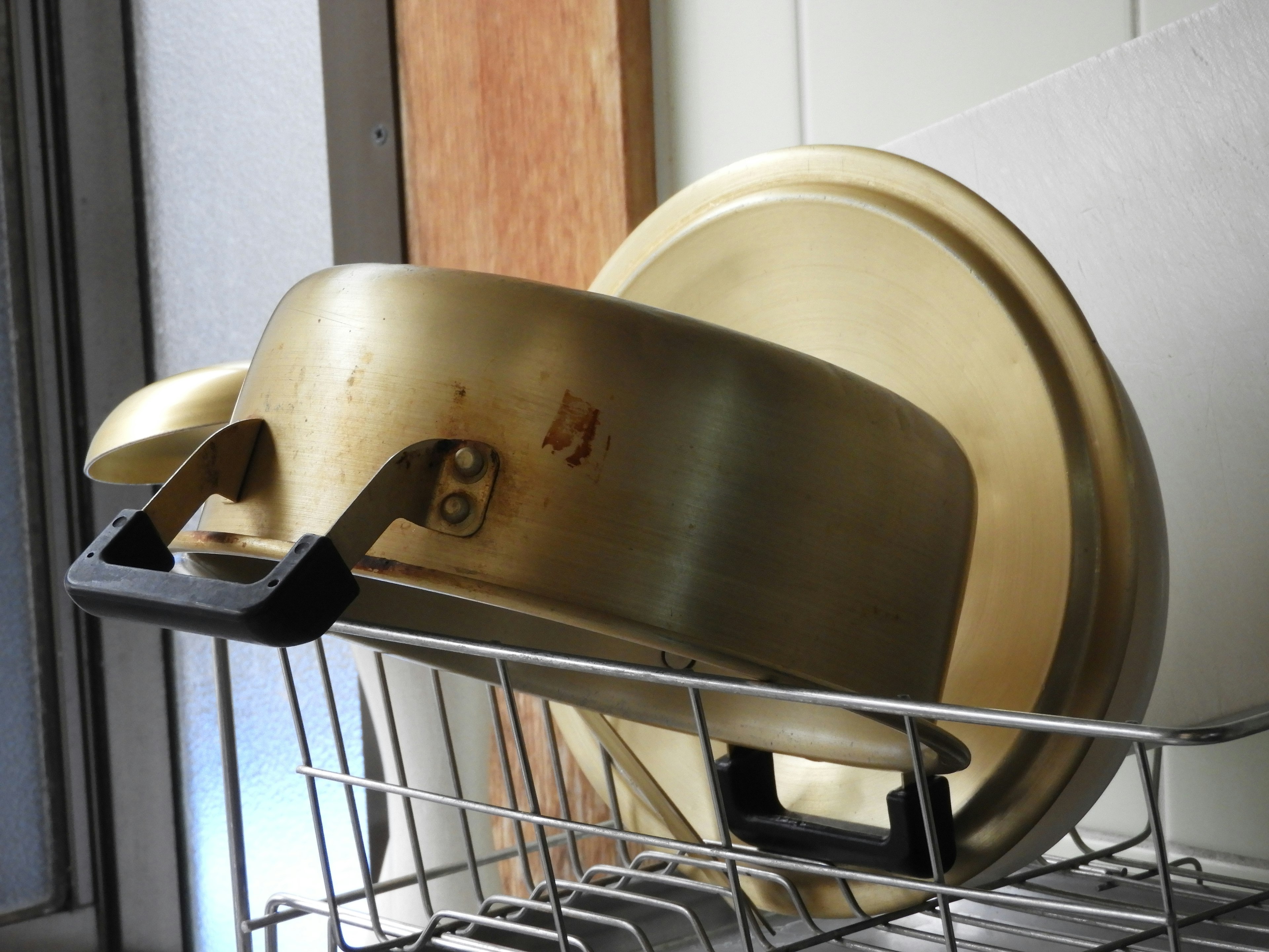 Gold pot and pan resting on a dish drying rack