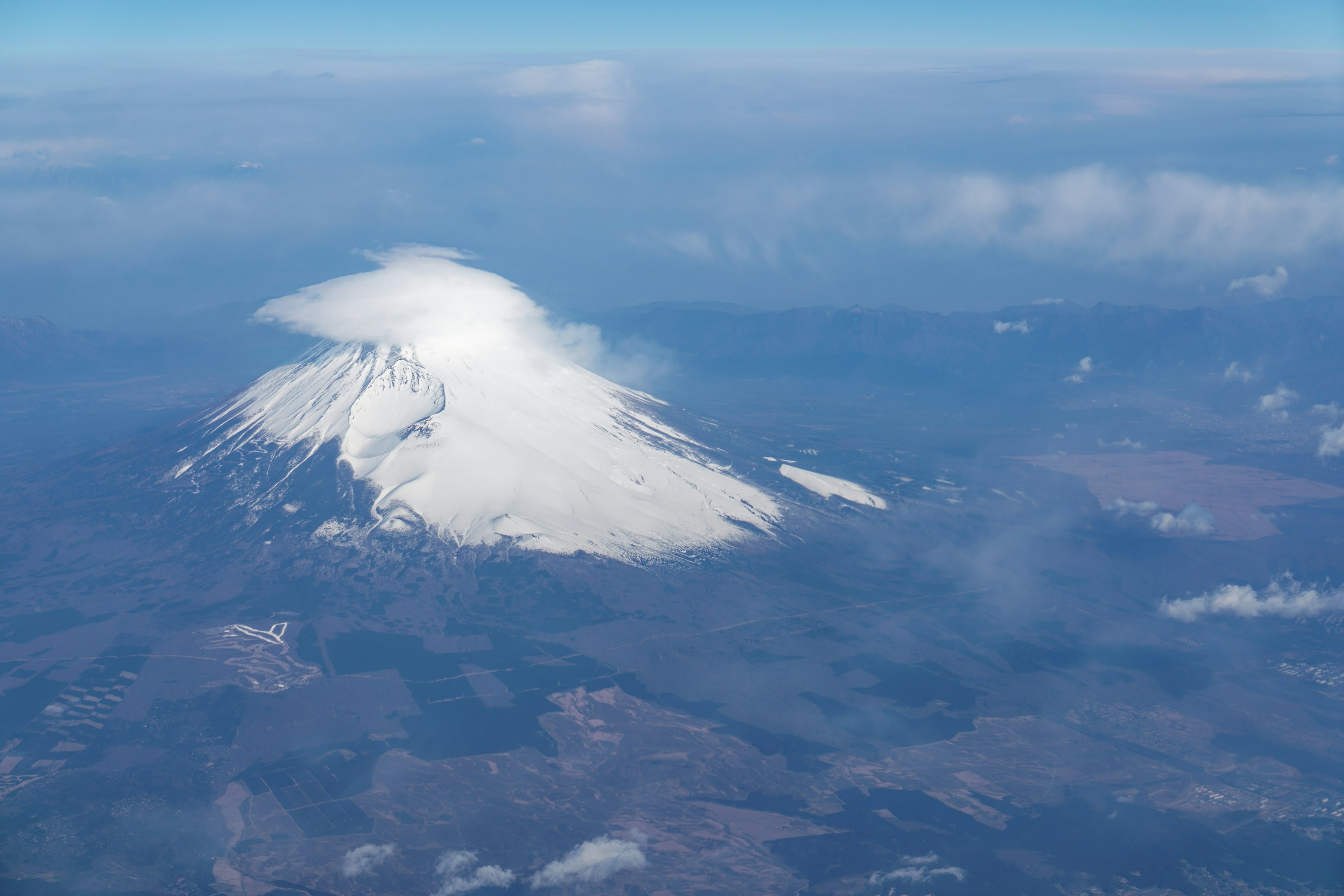 雪に覆われた山の頂上が雲に包まれている風景