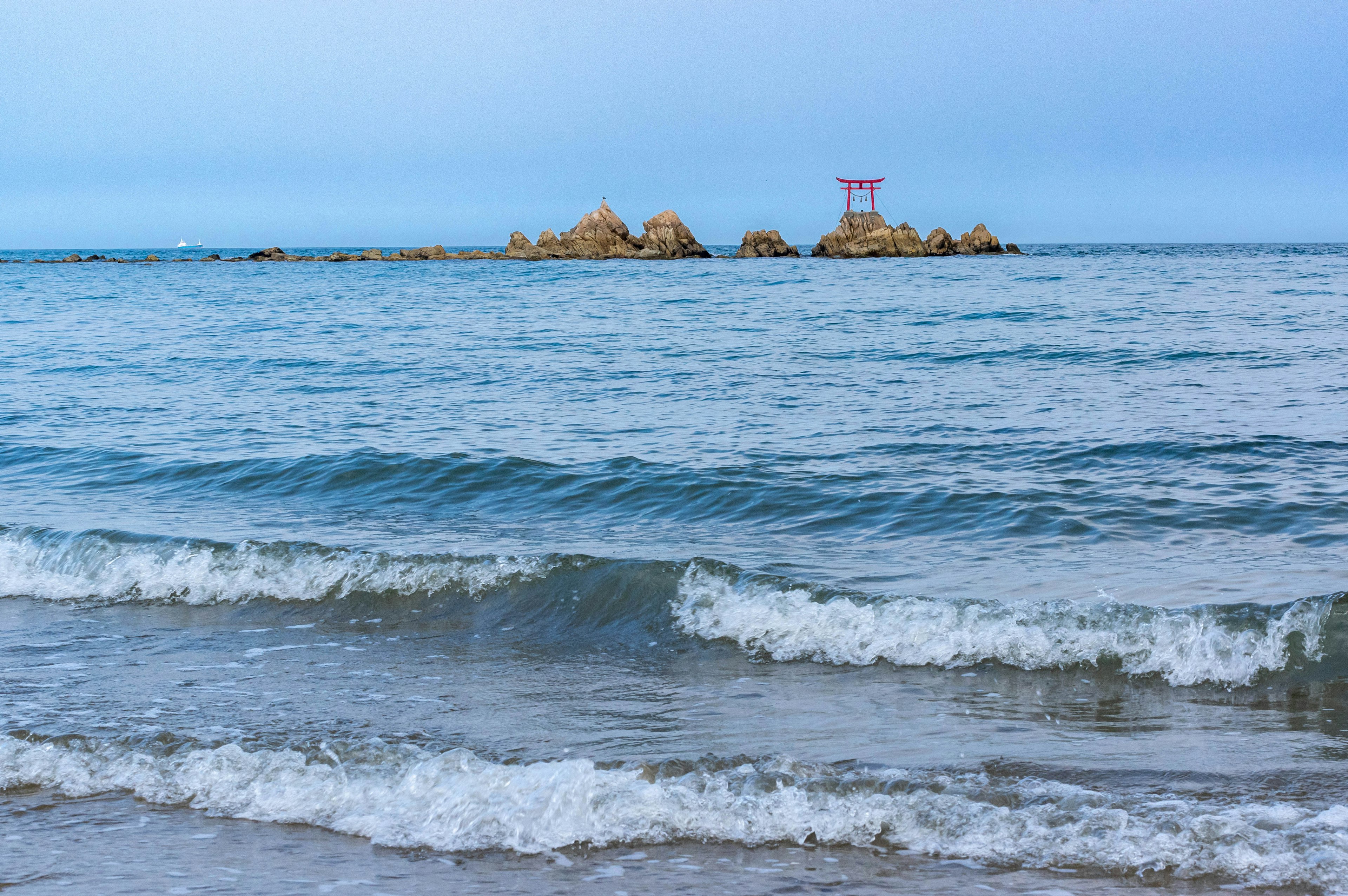 Vista di un mare calmo con un'isola piccola e onde dolci